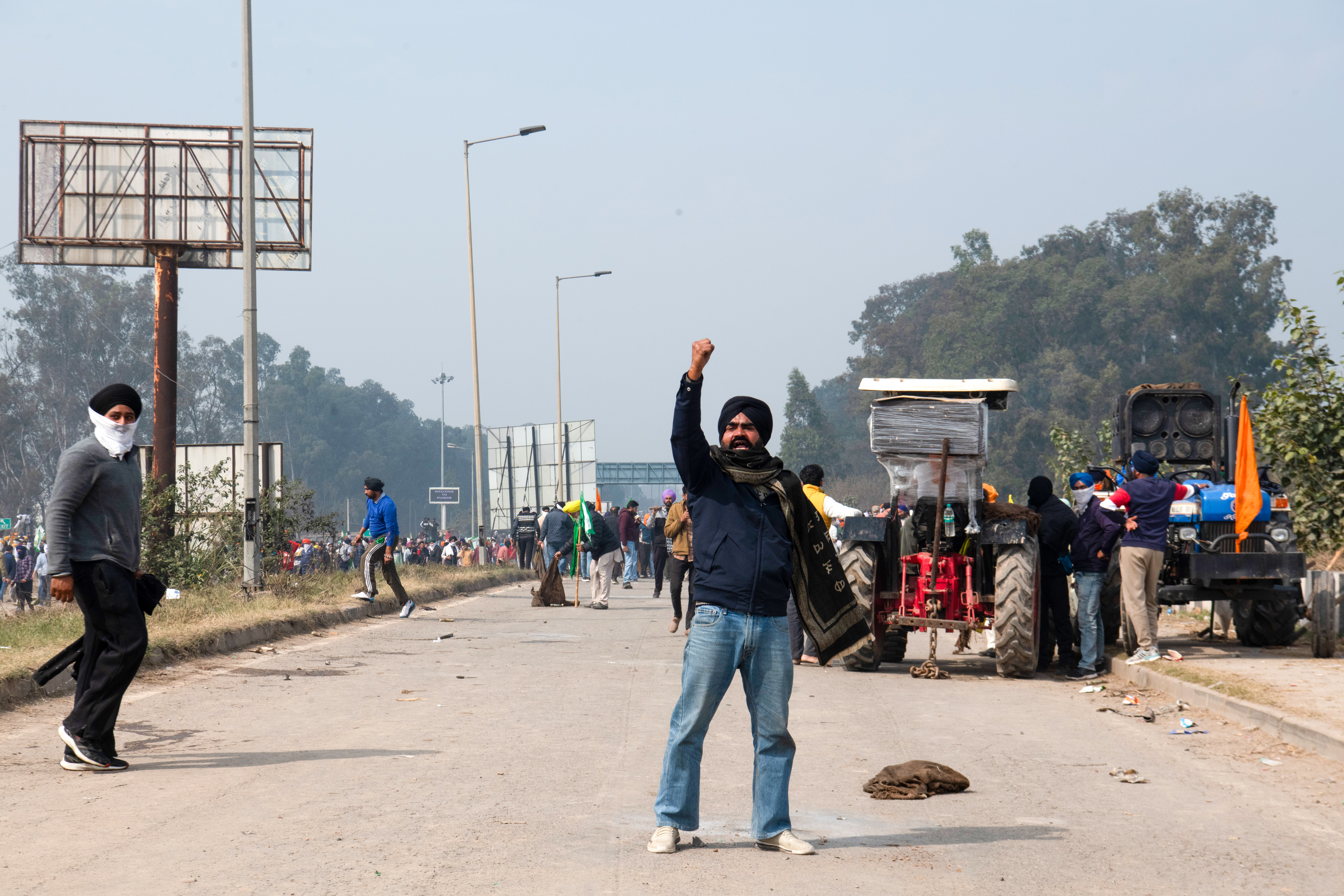 A protesting farmer raises slogans at the Sindhu border after being stopped from marching into Delhi to advocate for their demands.