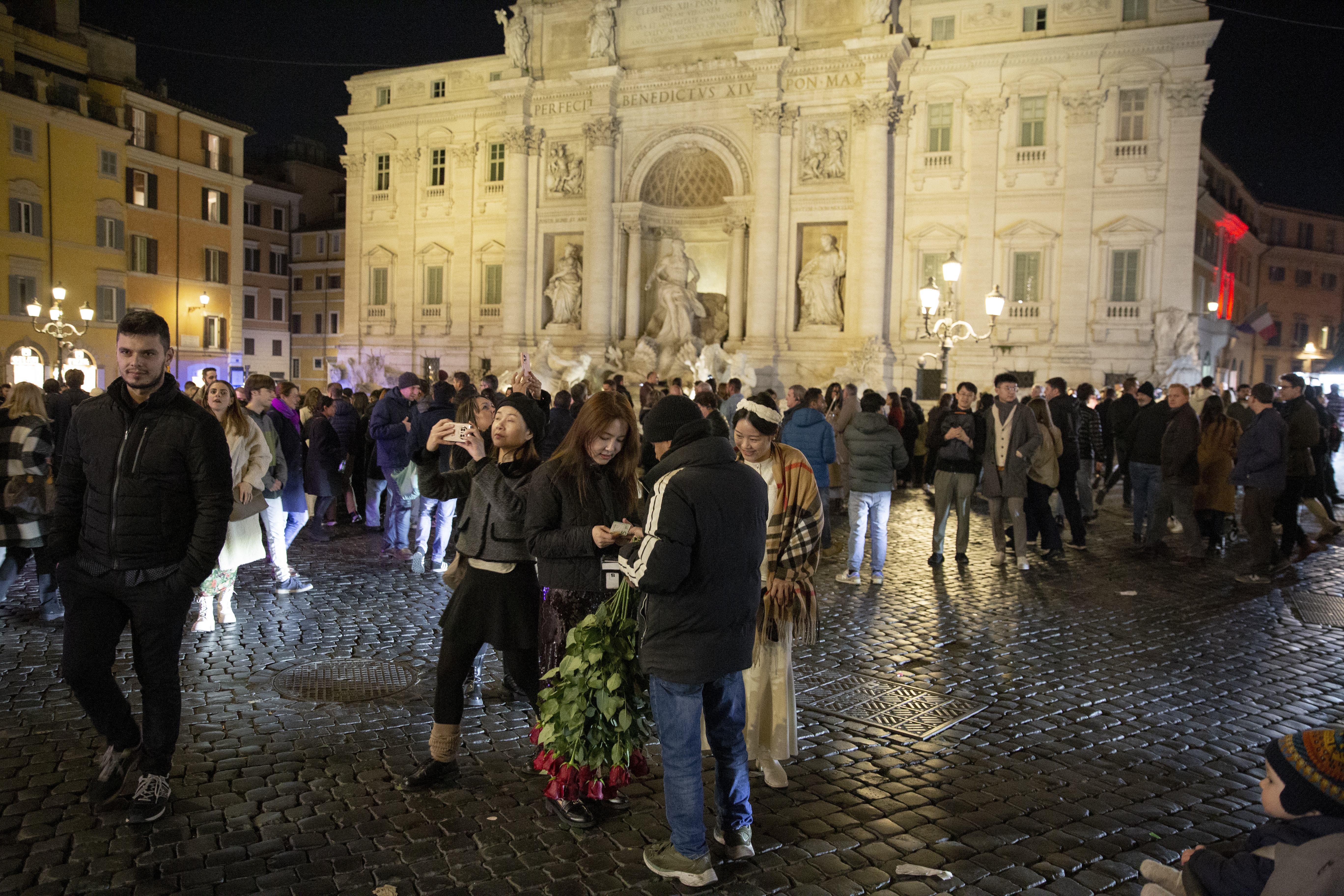 Rome, Italy, February 2nd, 2024. A rose vendor selling roses to two women in Fontana di Trevi, one of Rome’s busiest tourist destinations. Photo @ Agostino Petroni