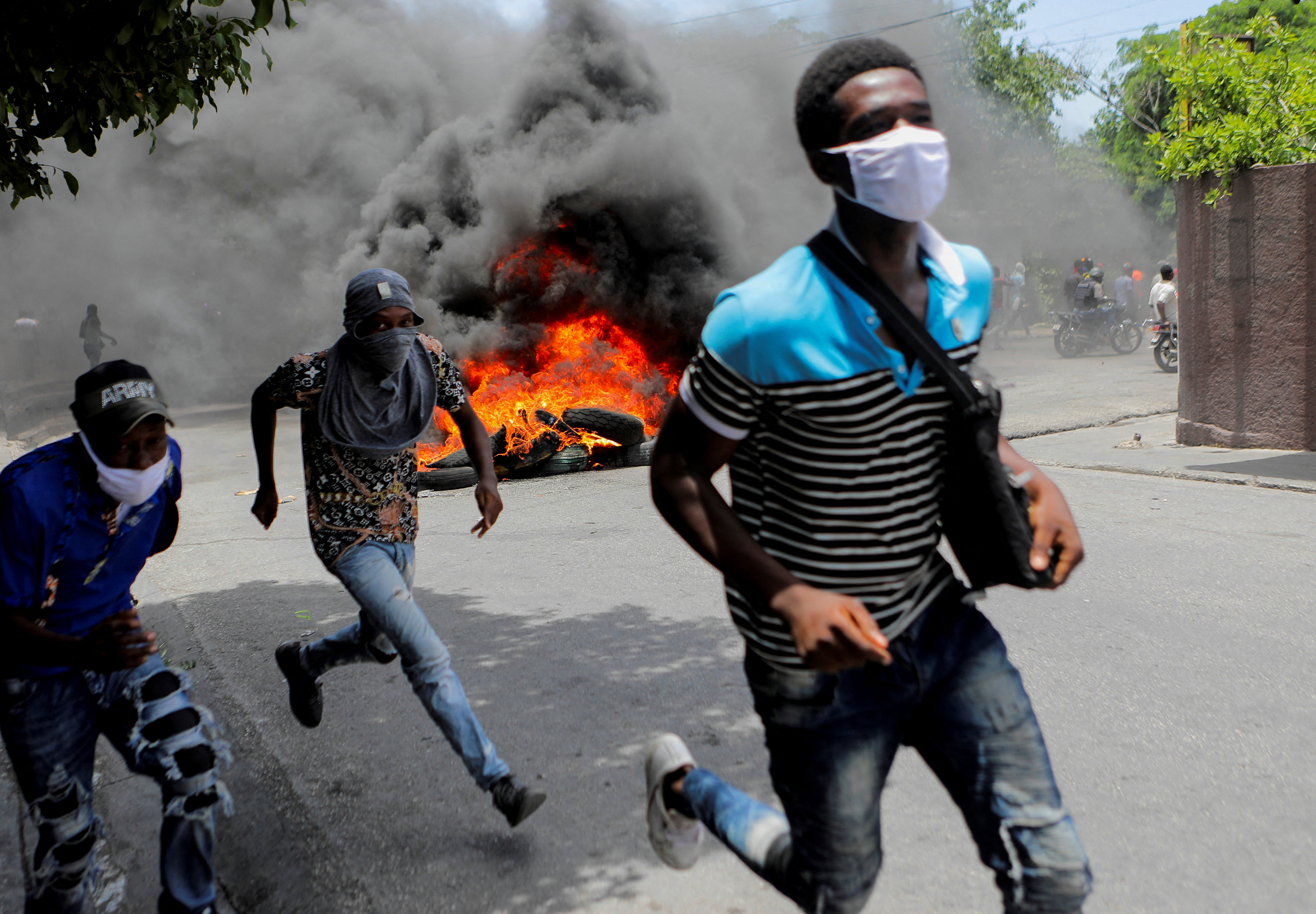 People run during a protest demanding an end to gang violence in Haiti