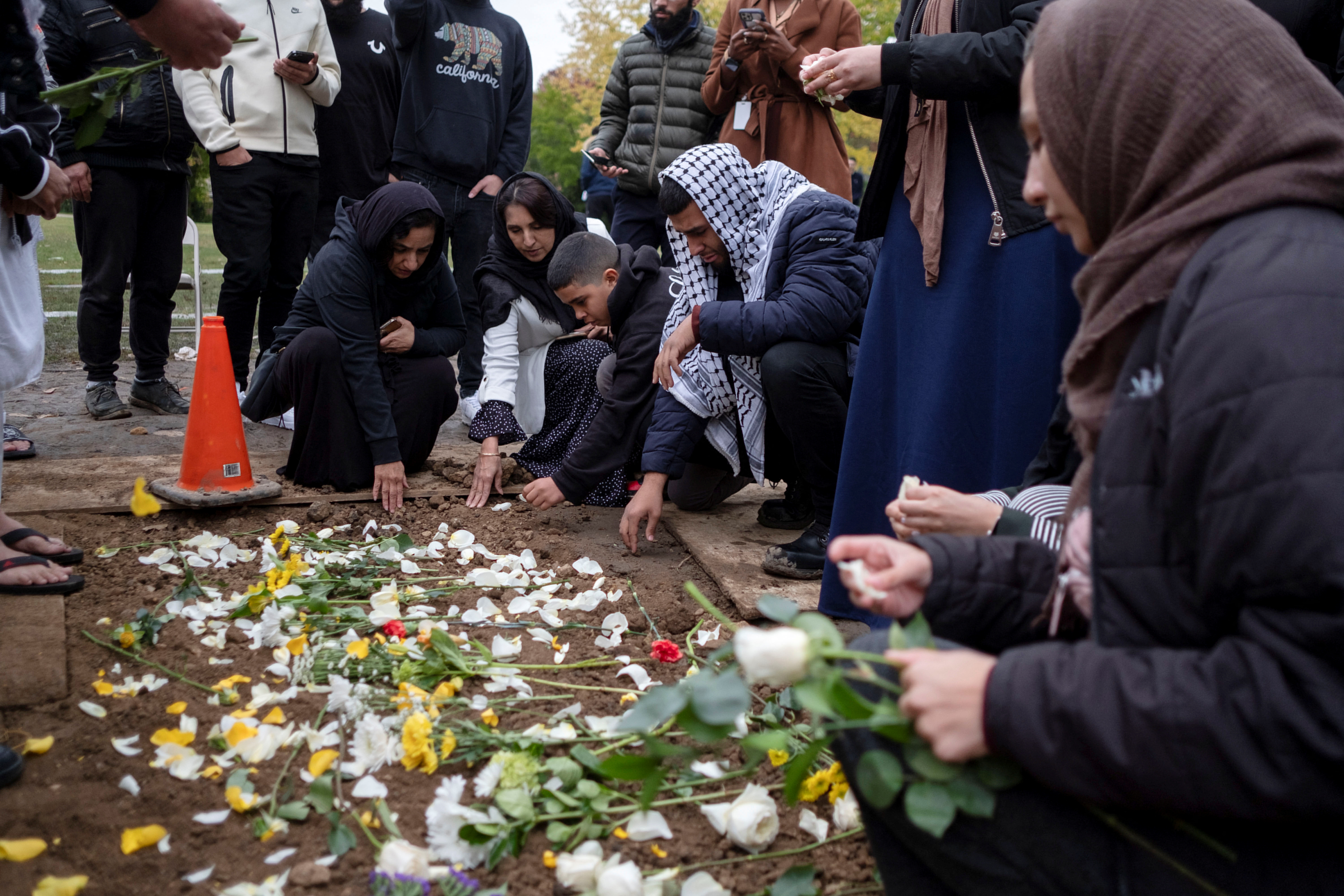 Mourners place flowers at the grave of Wadea Al-Fayoume, a six-year-old Palestinian American child, who was killed in a Chicago suburb