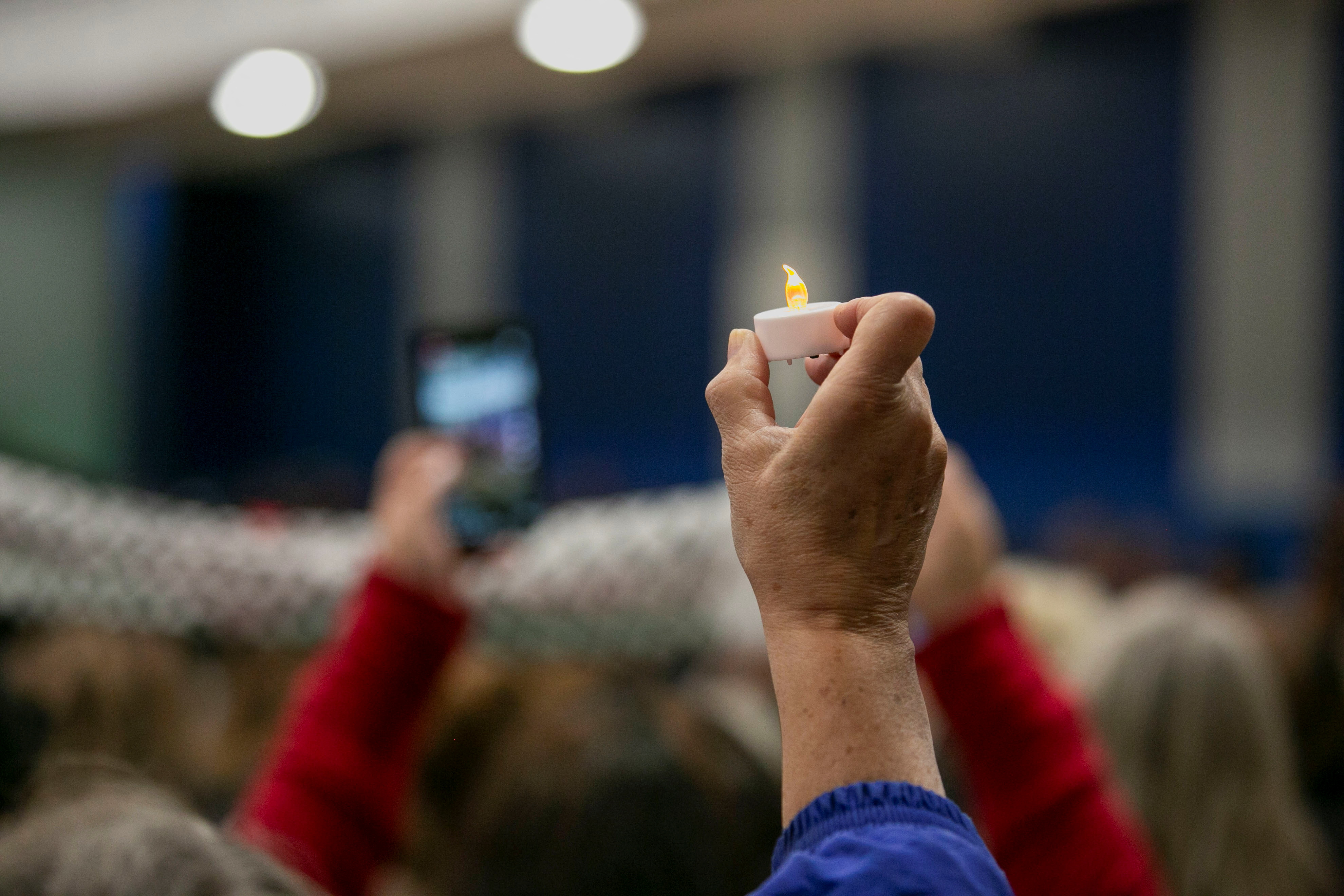 A mourner holds up a candle