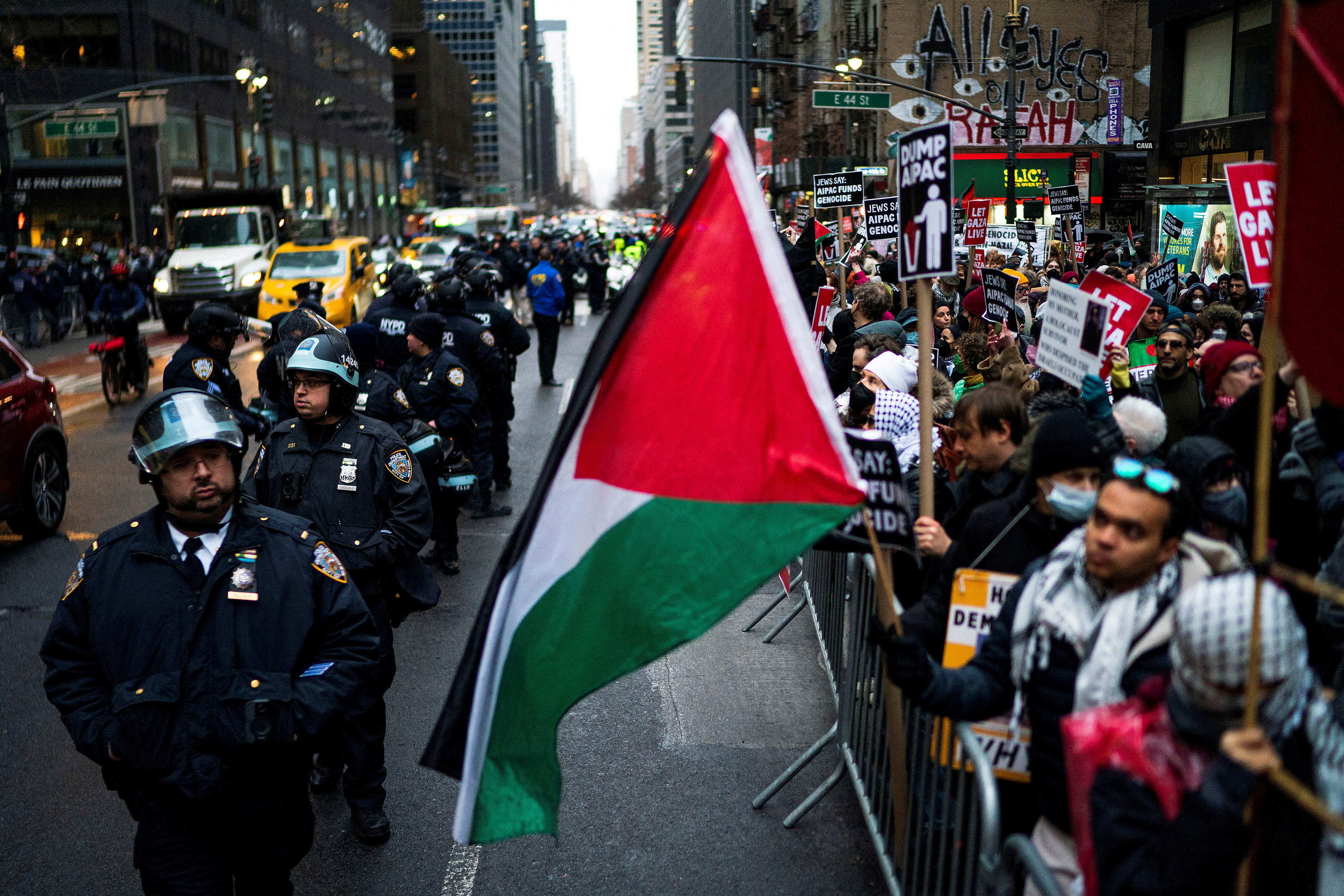 Protesters stand on the side of the rad in New York, across from a row of police officers