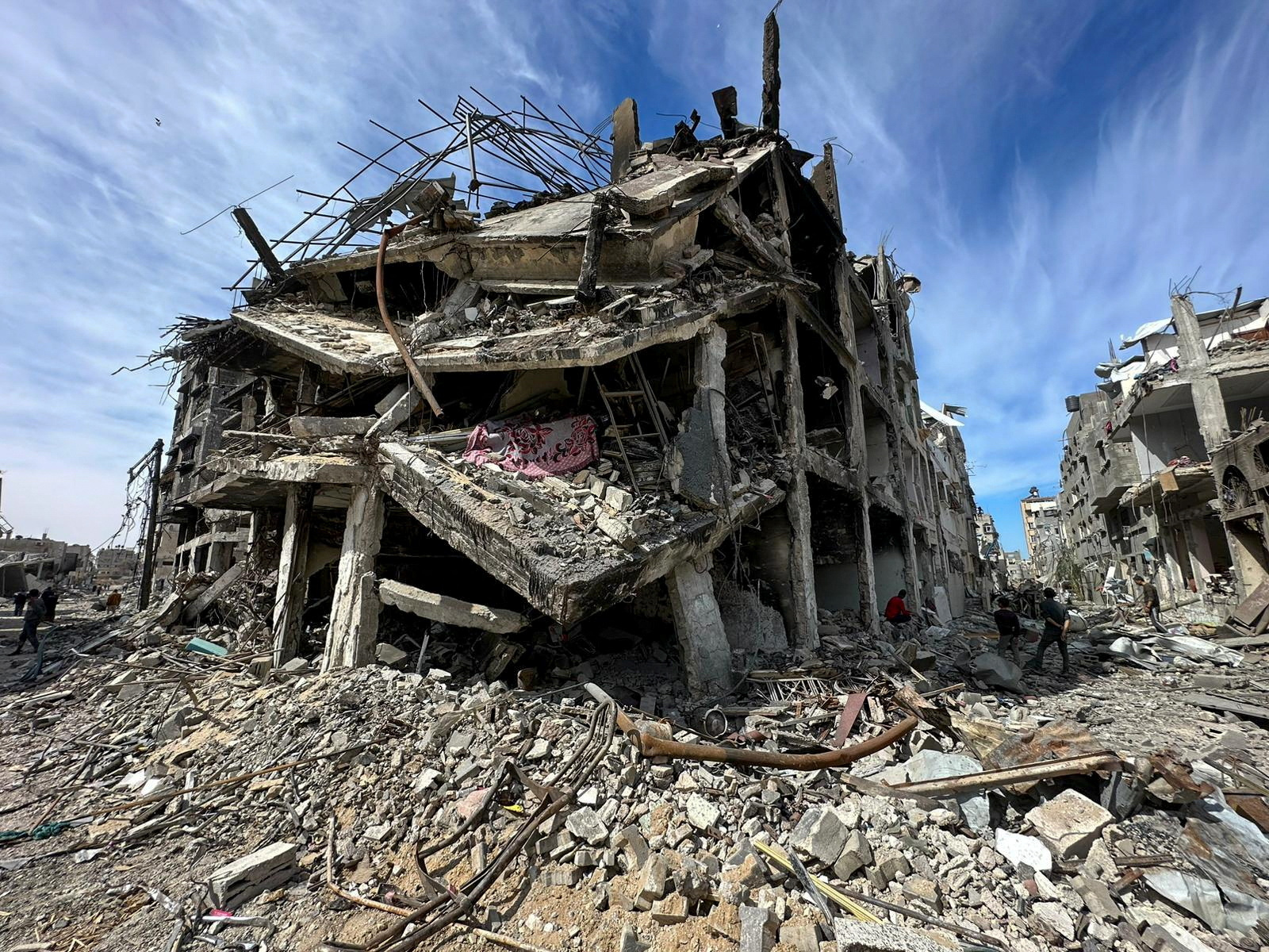 Palestinians stand near a damaged house at Zeitoun neighborhood after Israeli forces withdrew from the area, in Gaza City