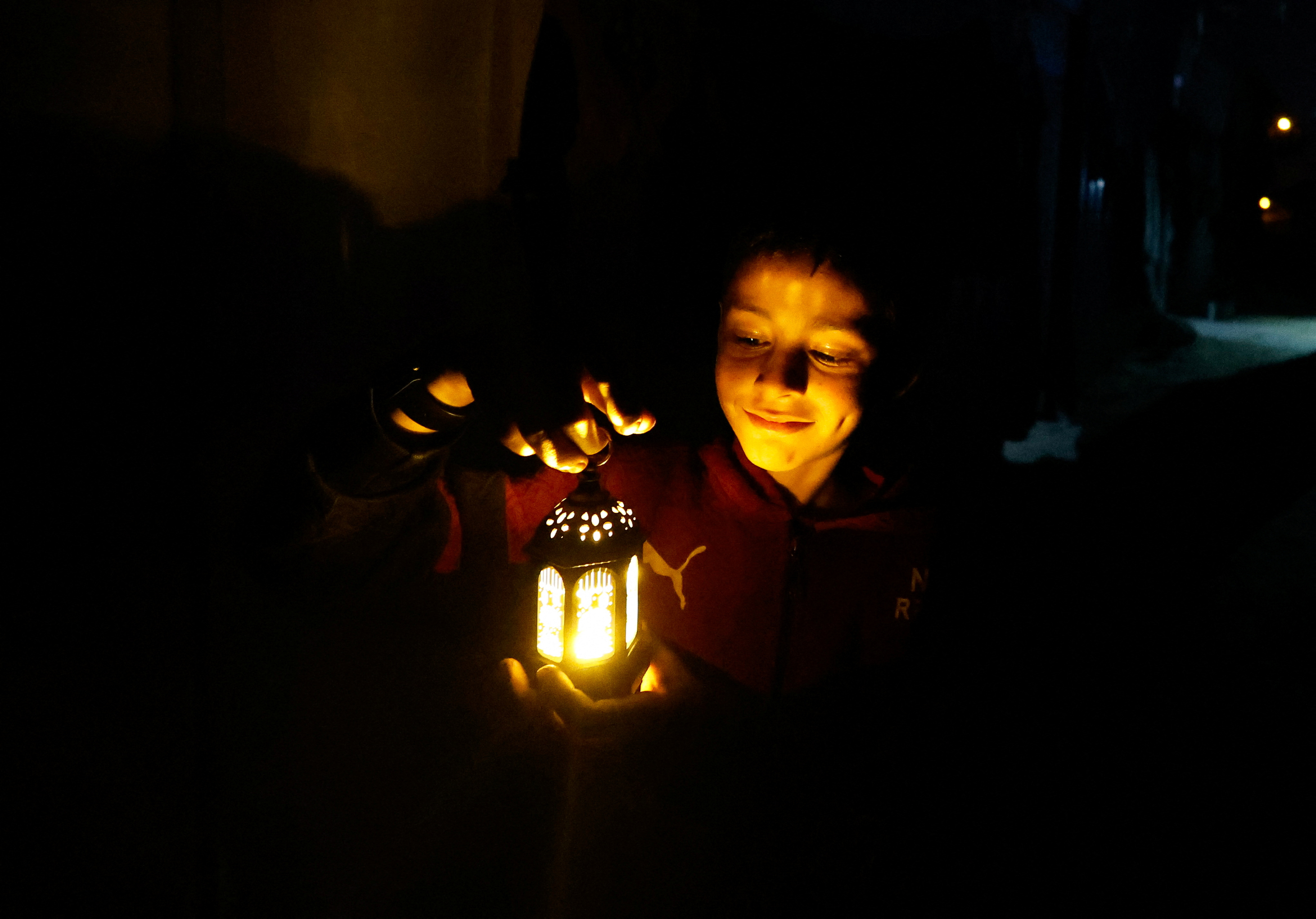 A child holds a lantern as displaced Palestinians prepare their tents for Ramadan, amid the ongoing conflict between Israel and the Palestinian Islamist group Hamas, in Rafah, in the southern Gaza Strip March 9, 2024