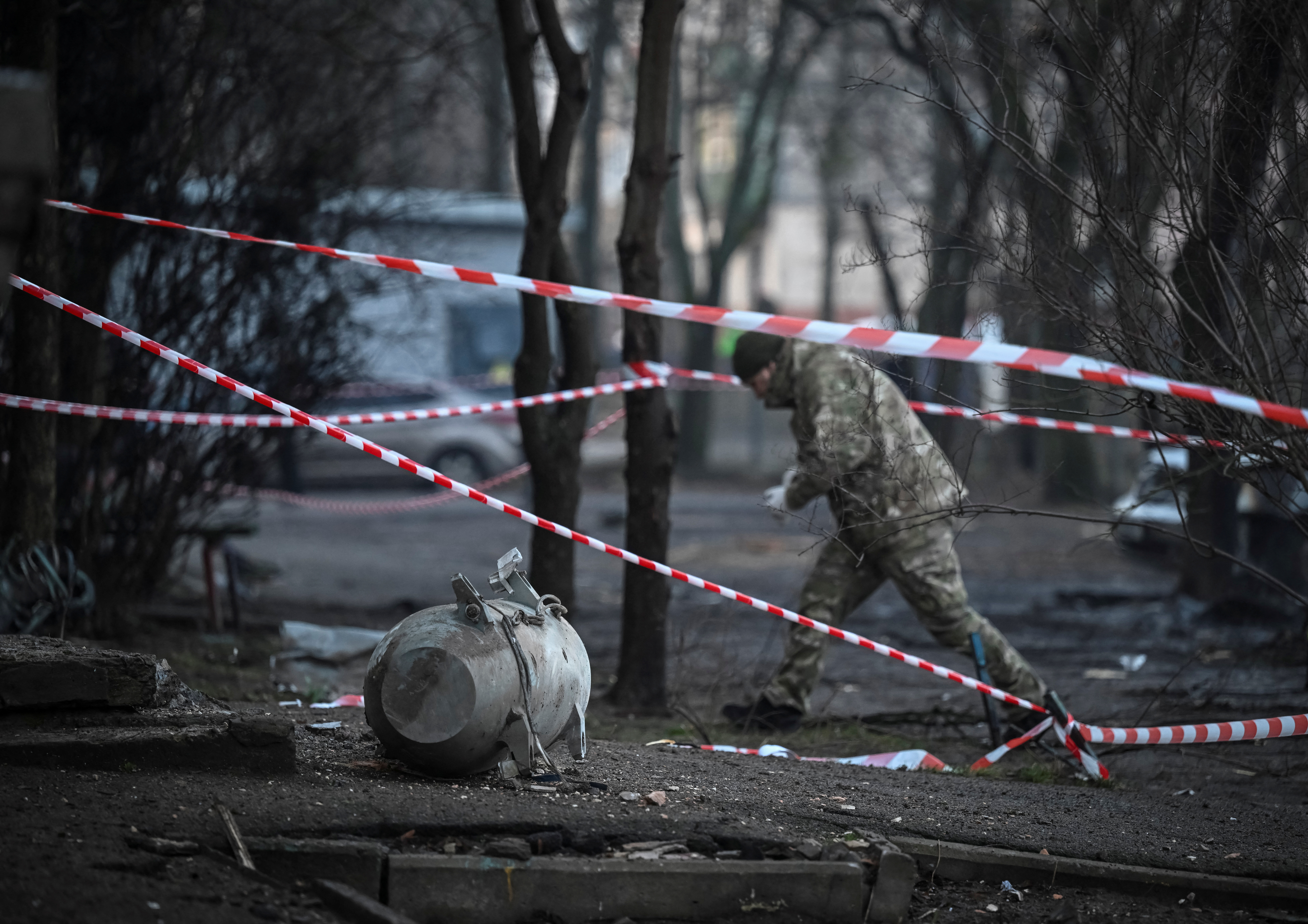 A bomb squad member works next to a part of a missile