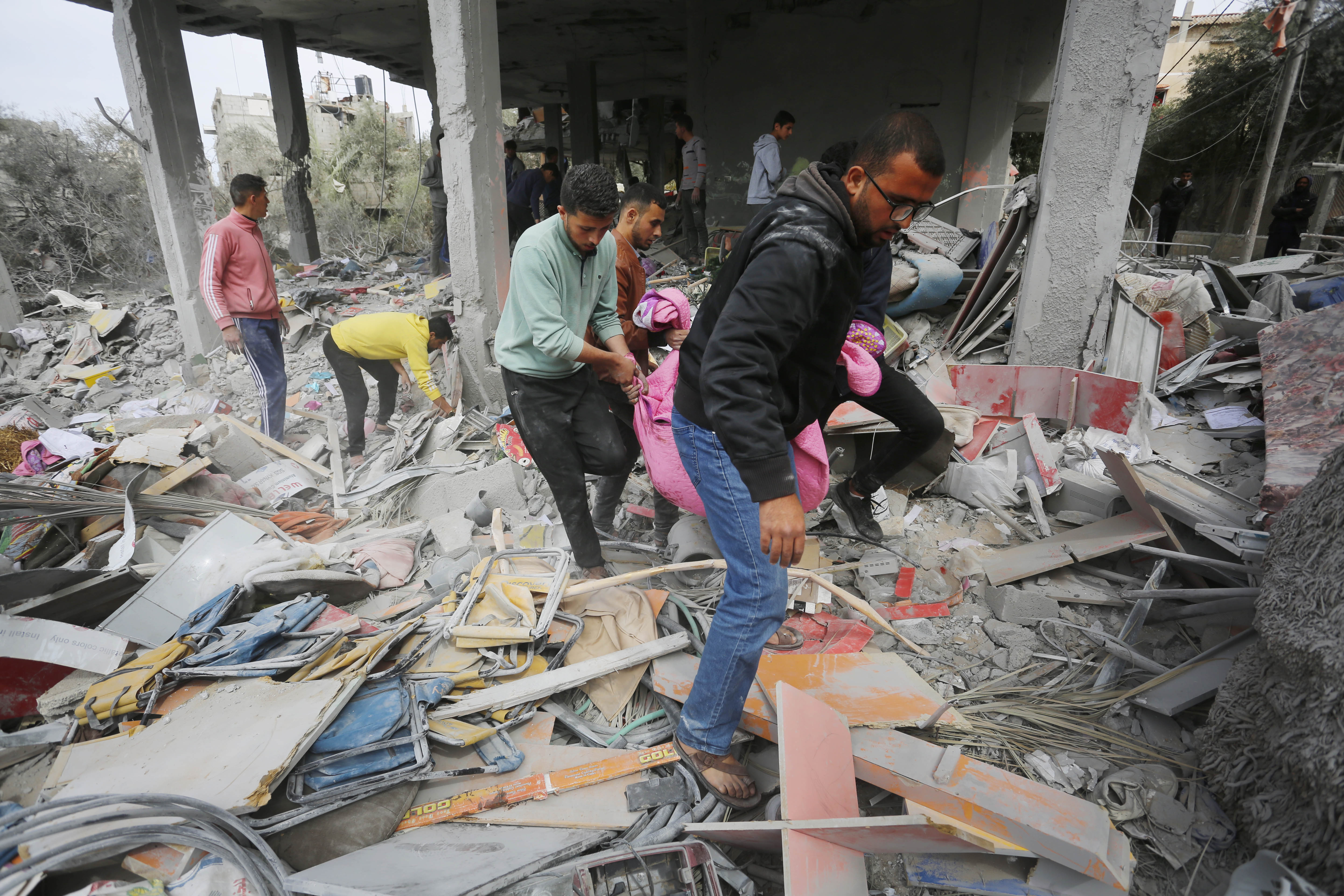 The lifeless body of a Palestinian is pulled from the rubble as Palestinian residents of the area carry out search and rescue works in the building heavily damaged after Israeli attack over an apartment building belonging to the Matir family in the Nuseirat Refugee Camp in Deir Al Balah