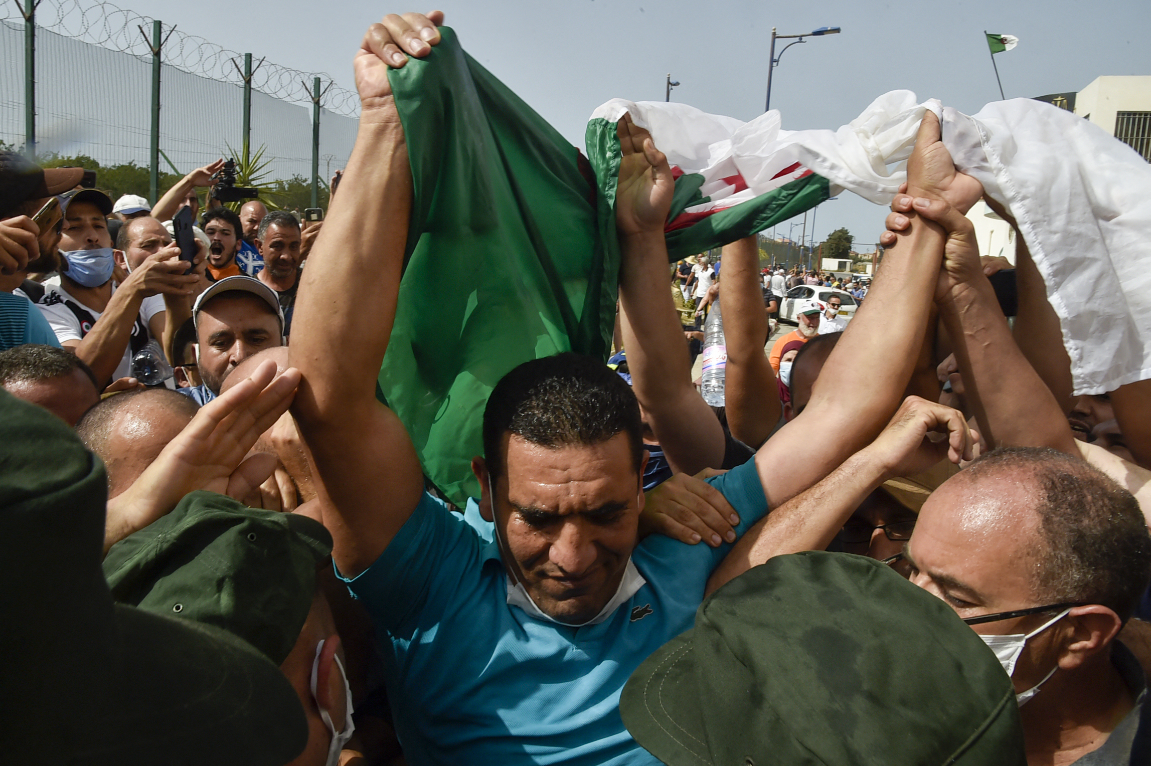 Karim Tabbou, one of the most prominent if not the best-known figure of "Hirak", is greeted upon his release from prison on July 2, 2020, outside the Kolea Prison near the city of Tipasa, 70km west of the capital Algiers. (Photo by RYAD KRAMDI / AFP)