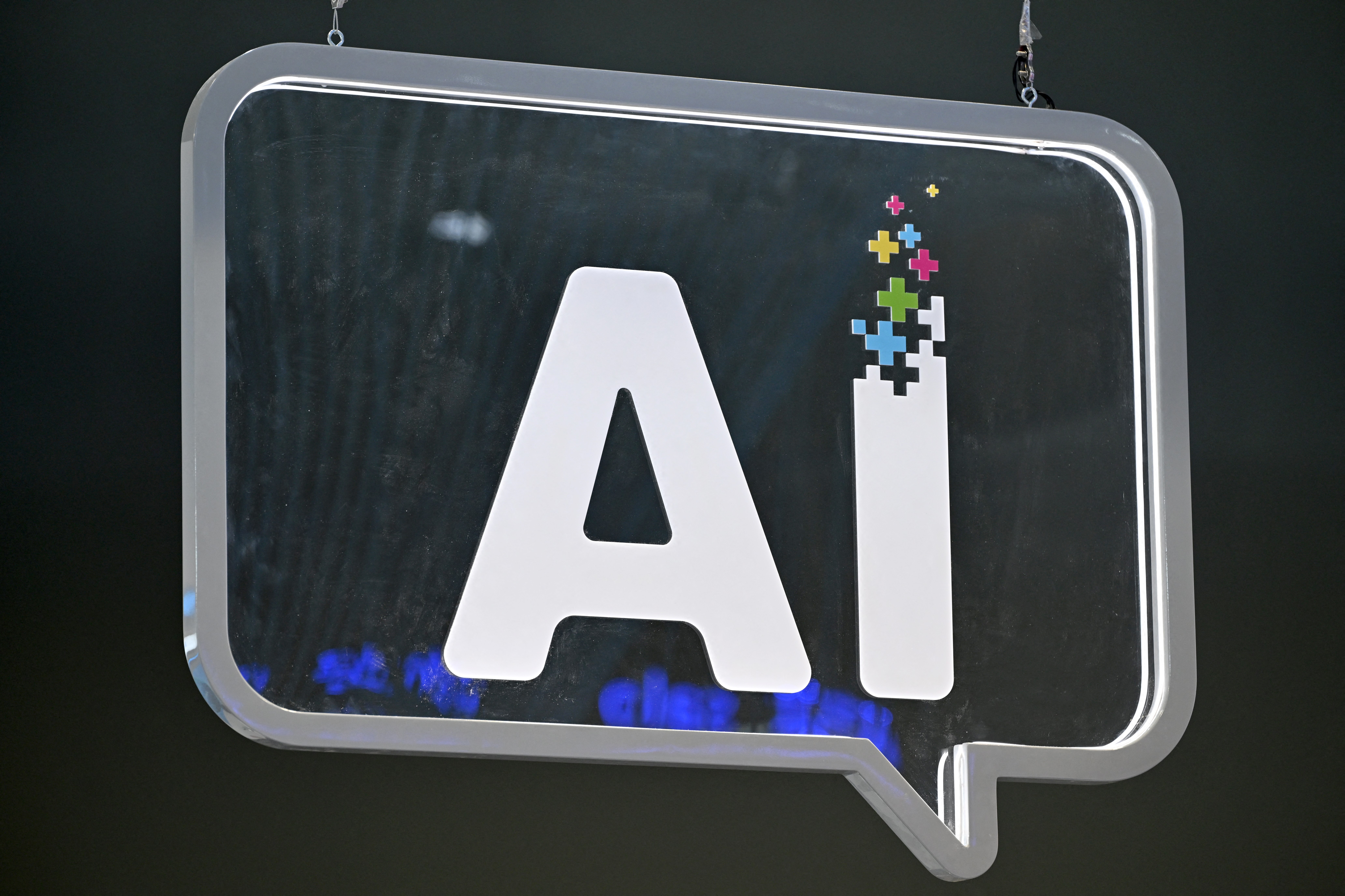 An AI (artificial intelligence) logo is pictured at the Mobile World Congress (MWC), the telecom industry's biggest annual gathering, in Barcelona on February 27, 2024. - The world's biggest mobile phone fair throws open its doors in Barcelona with the sector looking to artificial intelligence to try and reverse declining sales. (Photo by Josep LAGO / AFP)