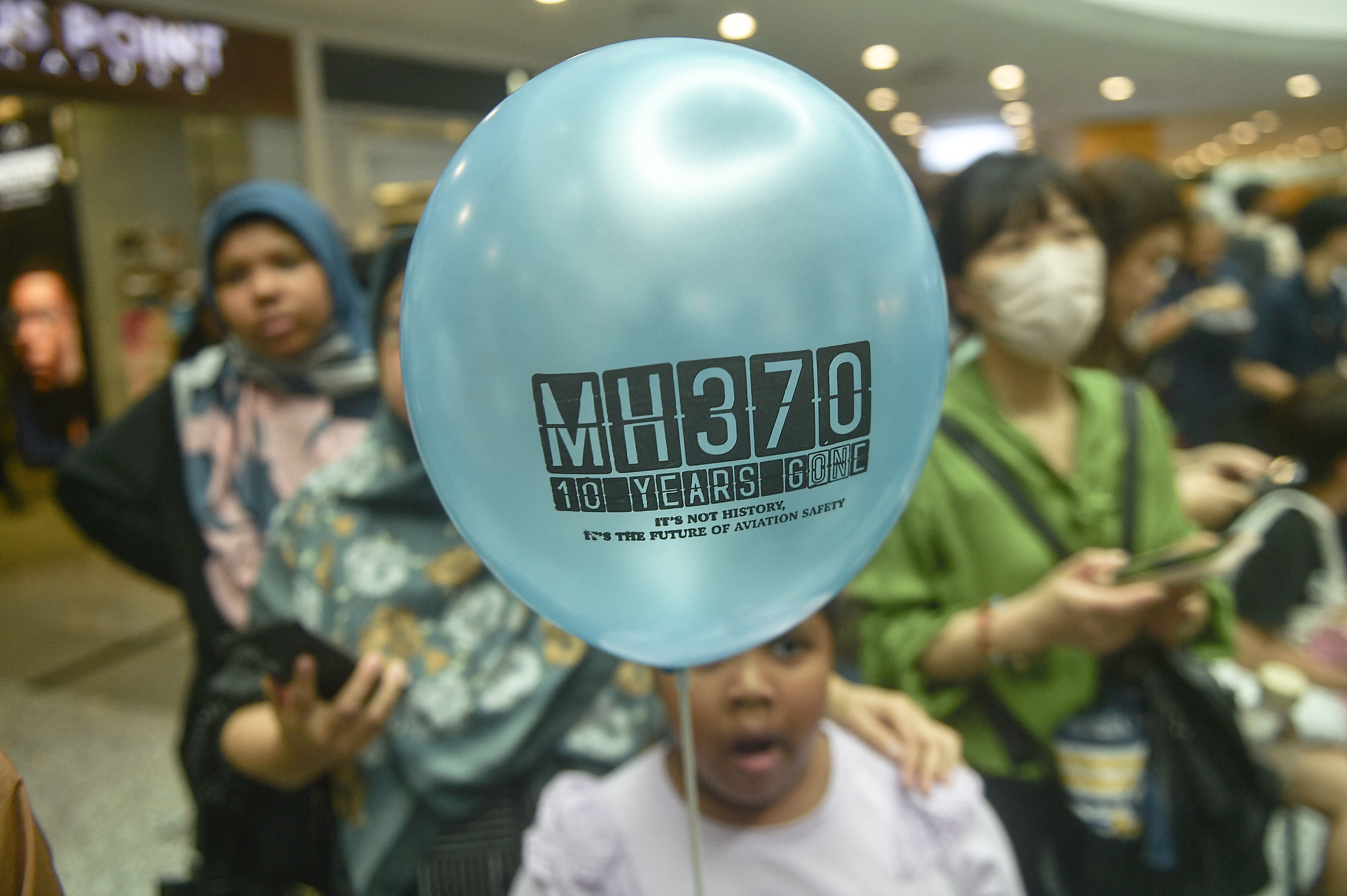 A person holds a balloon during an event held by relatives of the passengers and supporters to mark the 10th year since the Malaysia Airlines flight MH370