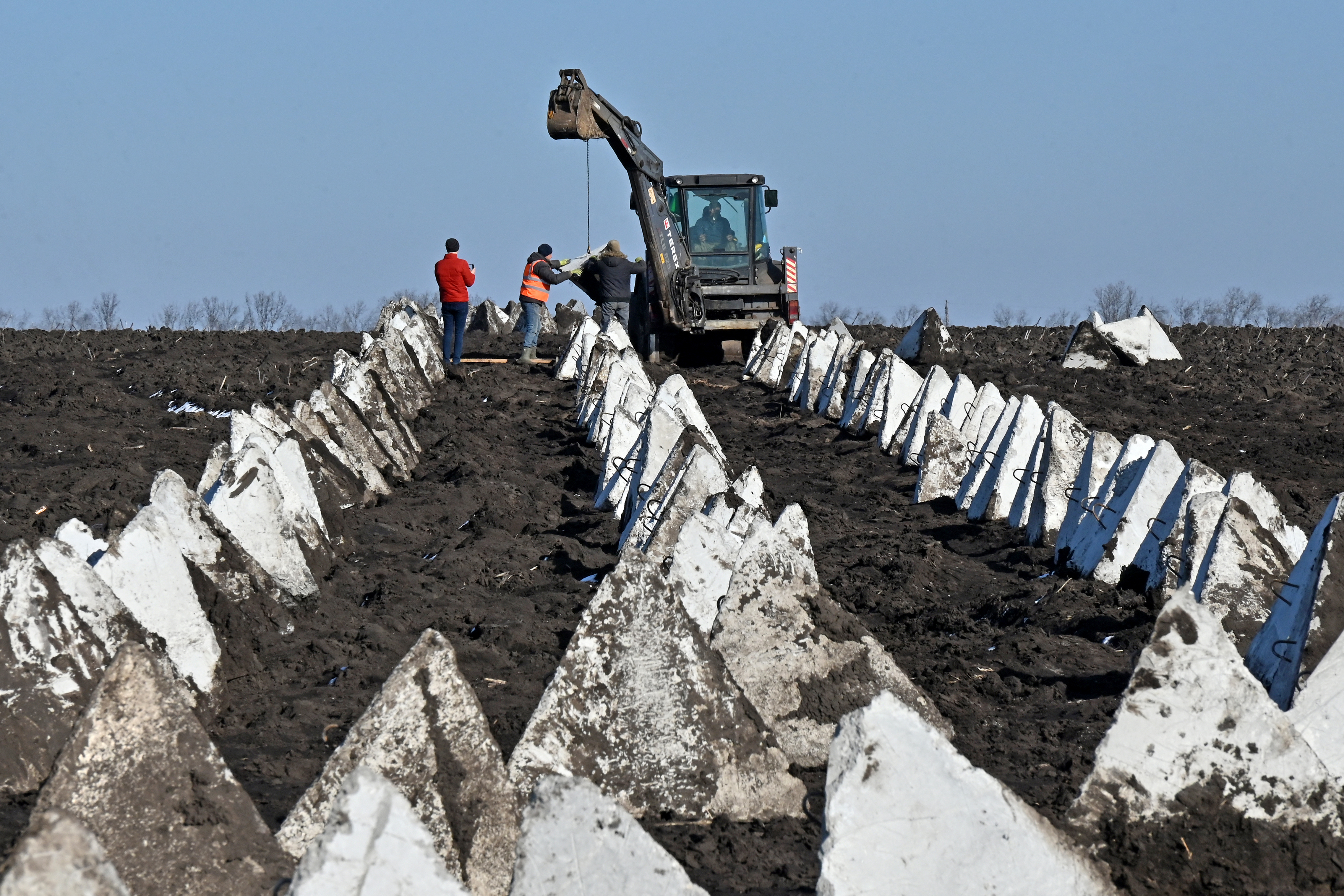 Rows of anti-tank defences known as dragon's teeth. They are white concrete and triangular.