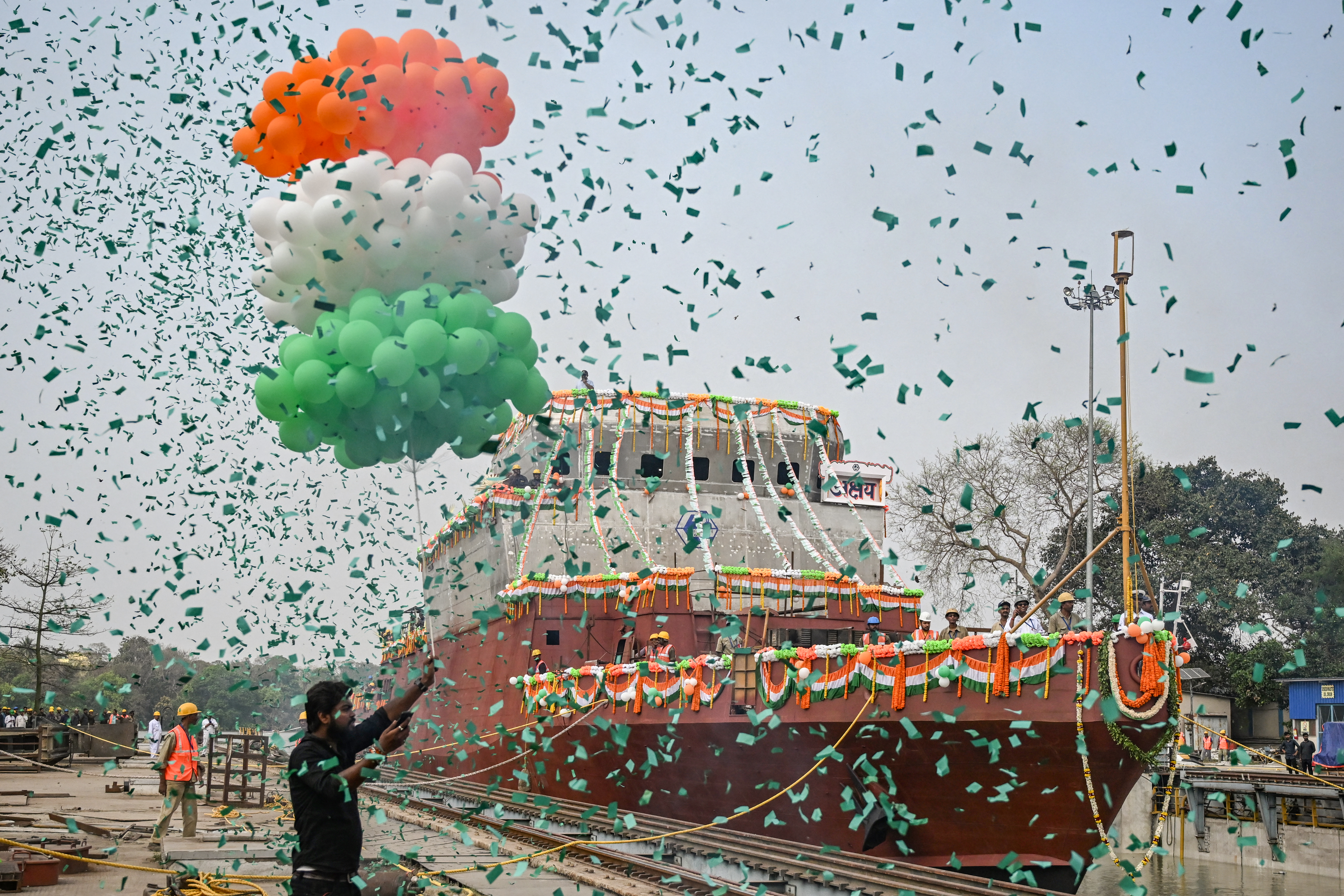 Employees of Garden Reach Shipbuilders and Engineers (GRSE) celebrate the launch of the Anti-Submarine Warfare Shallow Water Craft (ASW-SWC) corvette, at the GRSE dockyard in Kolkata on March 13