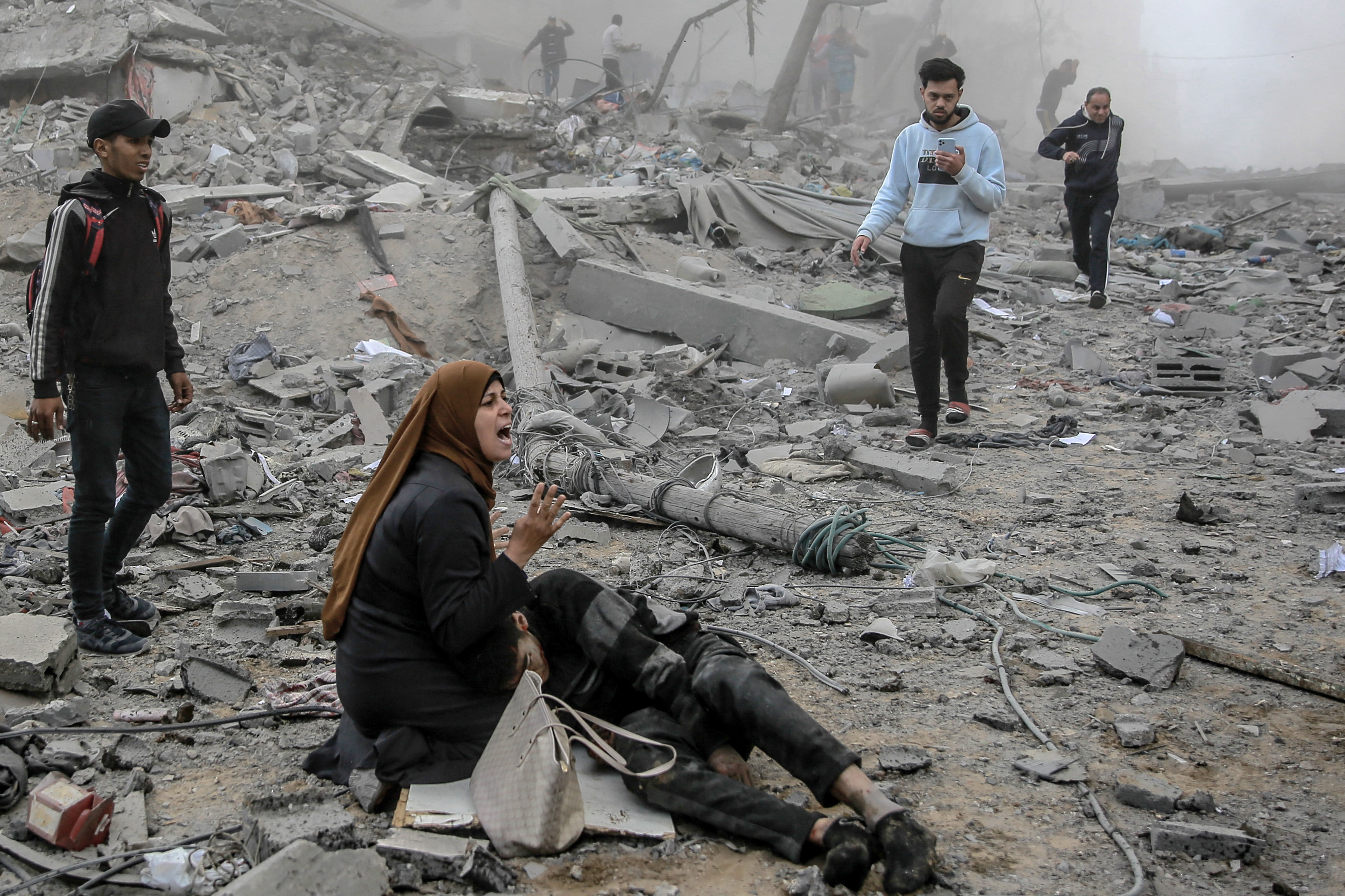 A Palestinian woman reacts as she craddles a wounded boy after Israeli bombardment in central Gaza City on March 18, 2024,