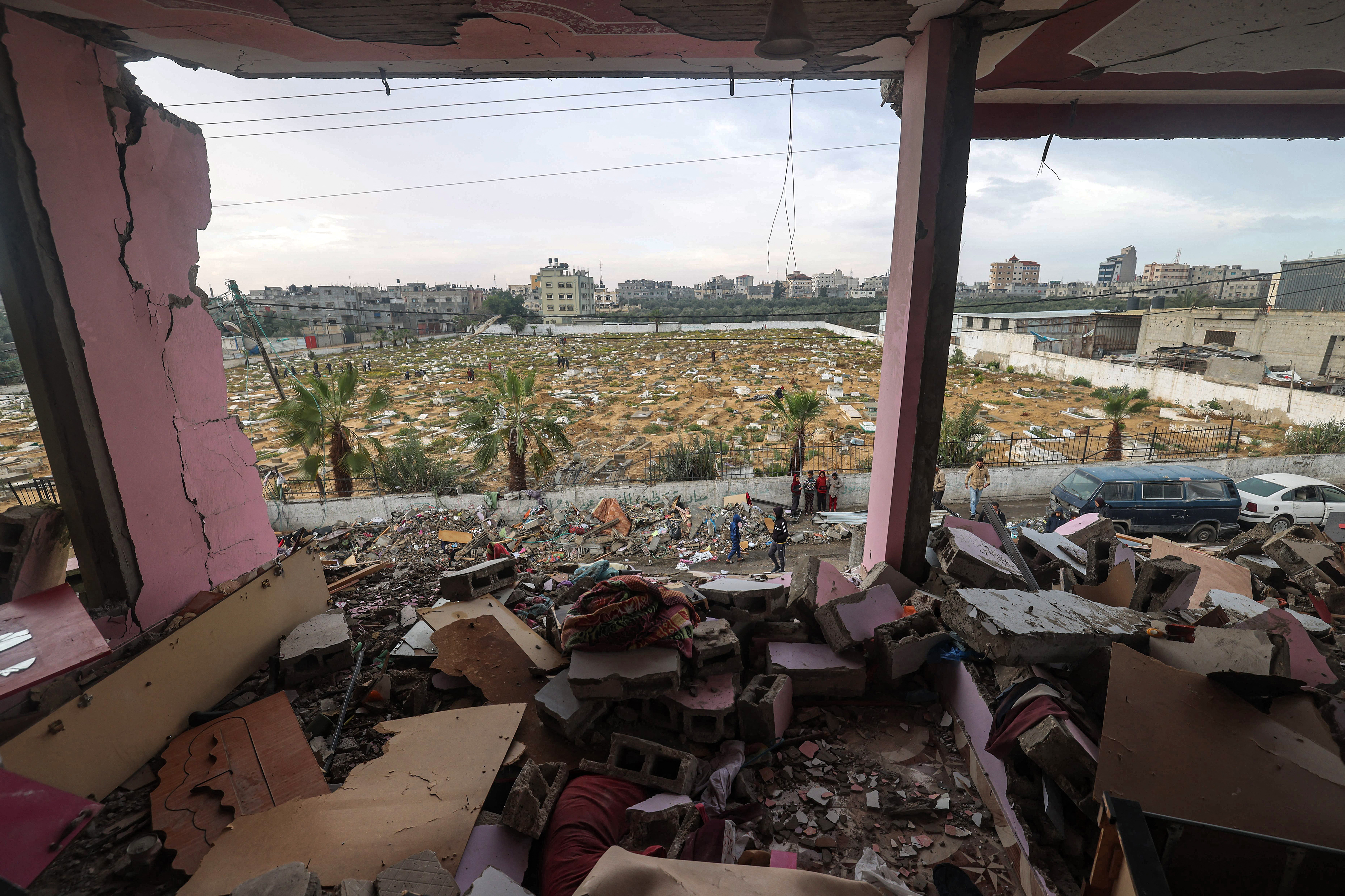 Children stand by rubble and debris outside a building that was hit by overnight Israeli bombardment in Rafah