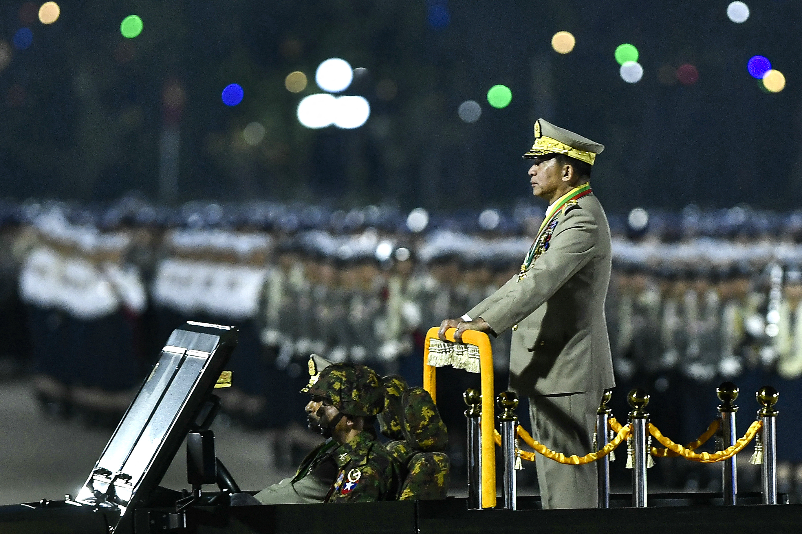 Min Aung Hlaing stands on the back of an open-topped military vehicle during Wednesday night's parade.