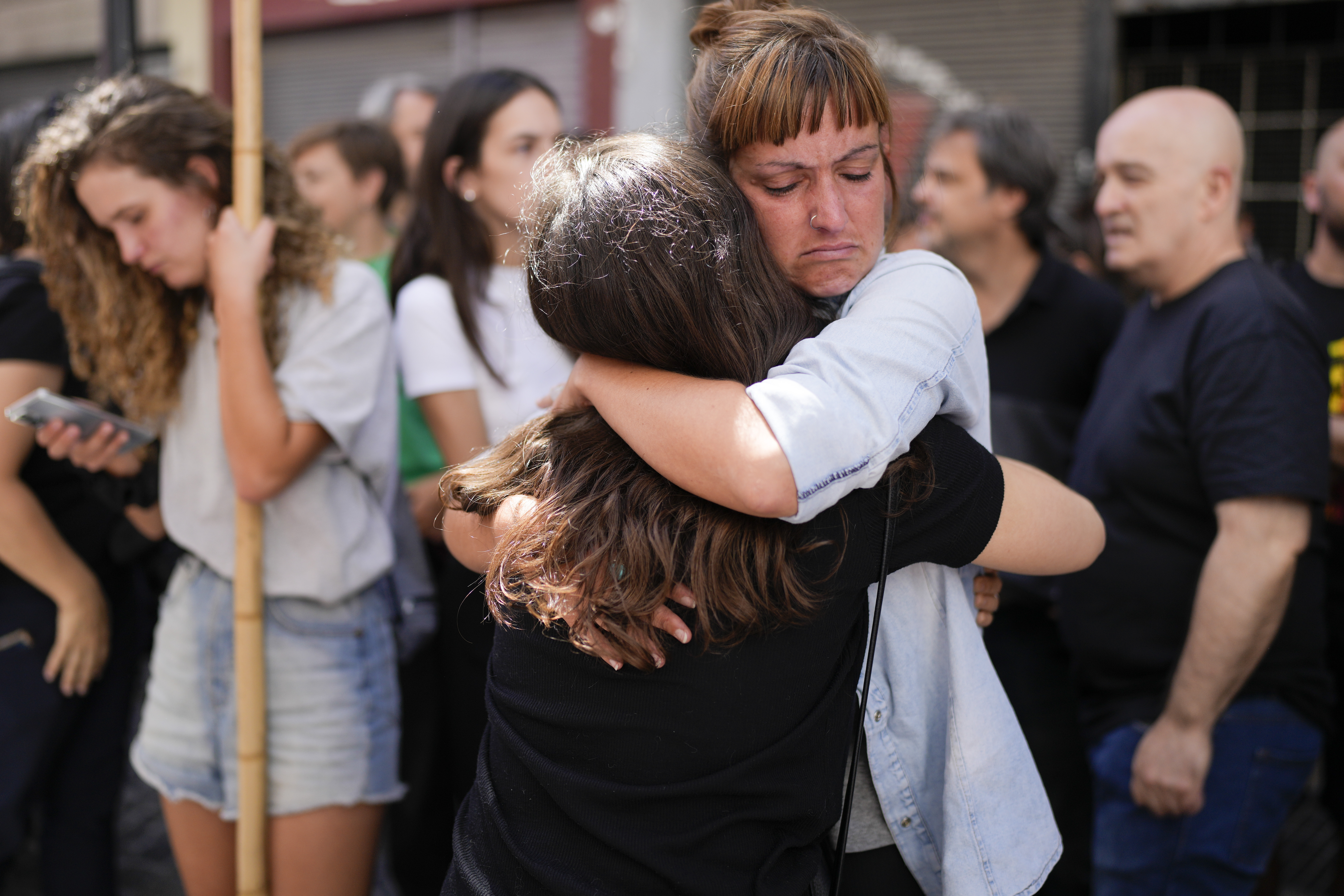 Telam workers hug outside the state-run Telam news agency in Buenos Aires, Argentina, Monday, March 4