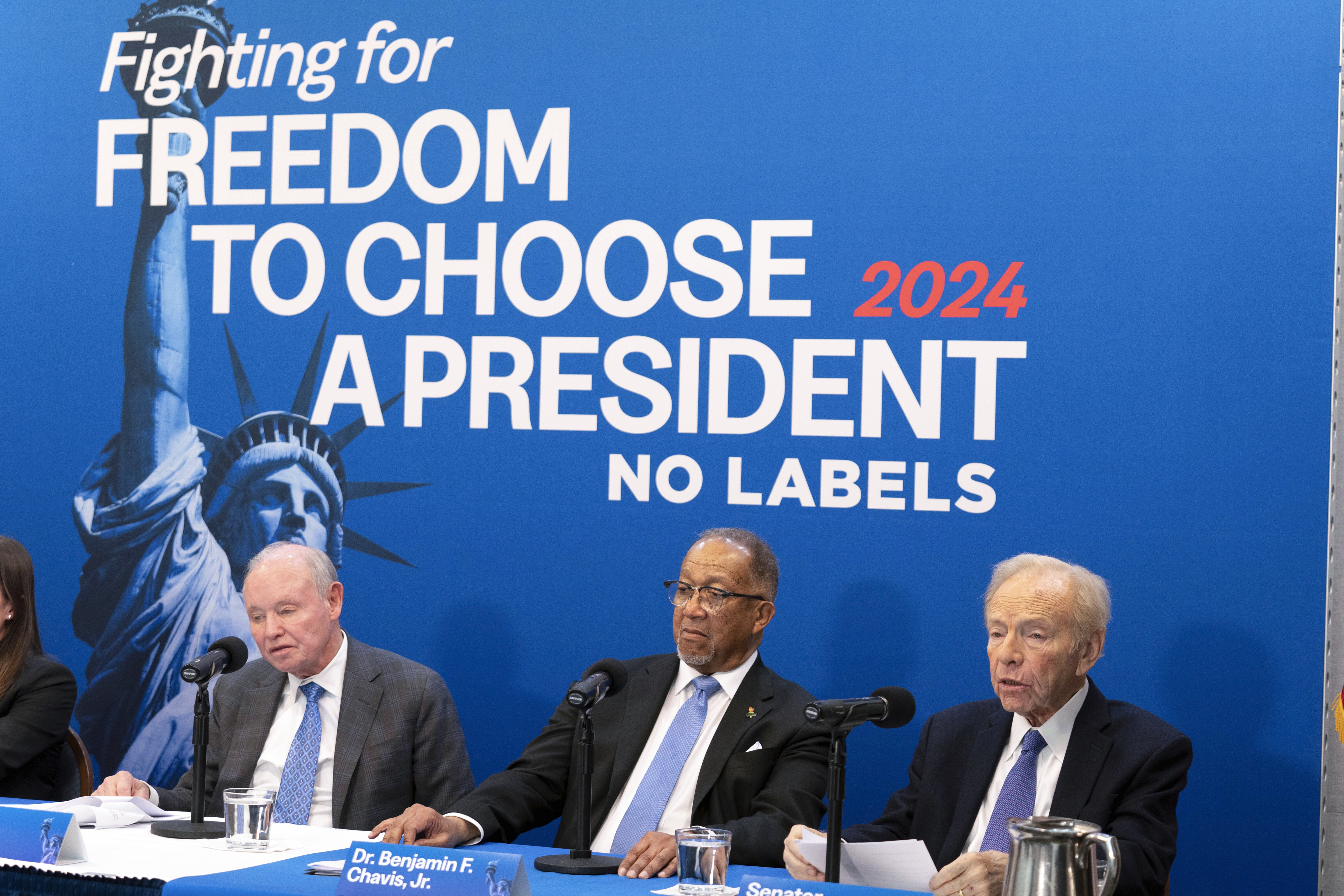 Joe Lieberman sits on a No Labels panel with two other people under the slogan "Fighting for freedom to choose a president. No Labels."