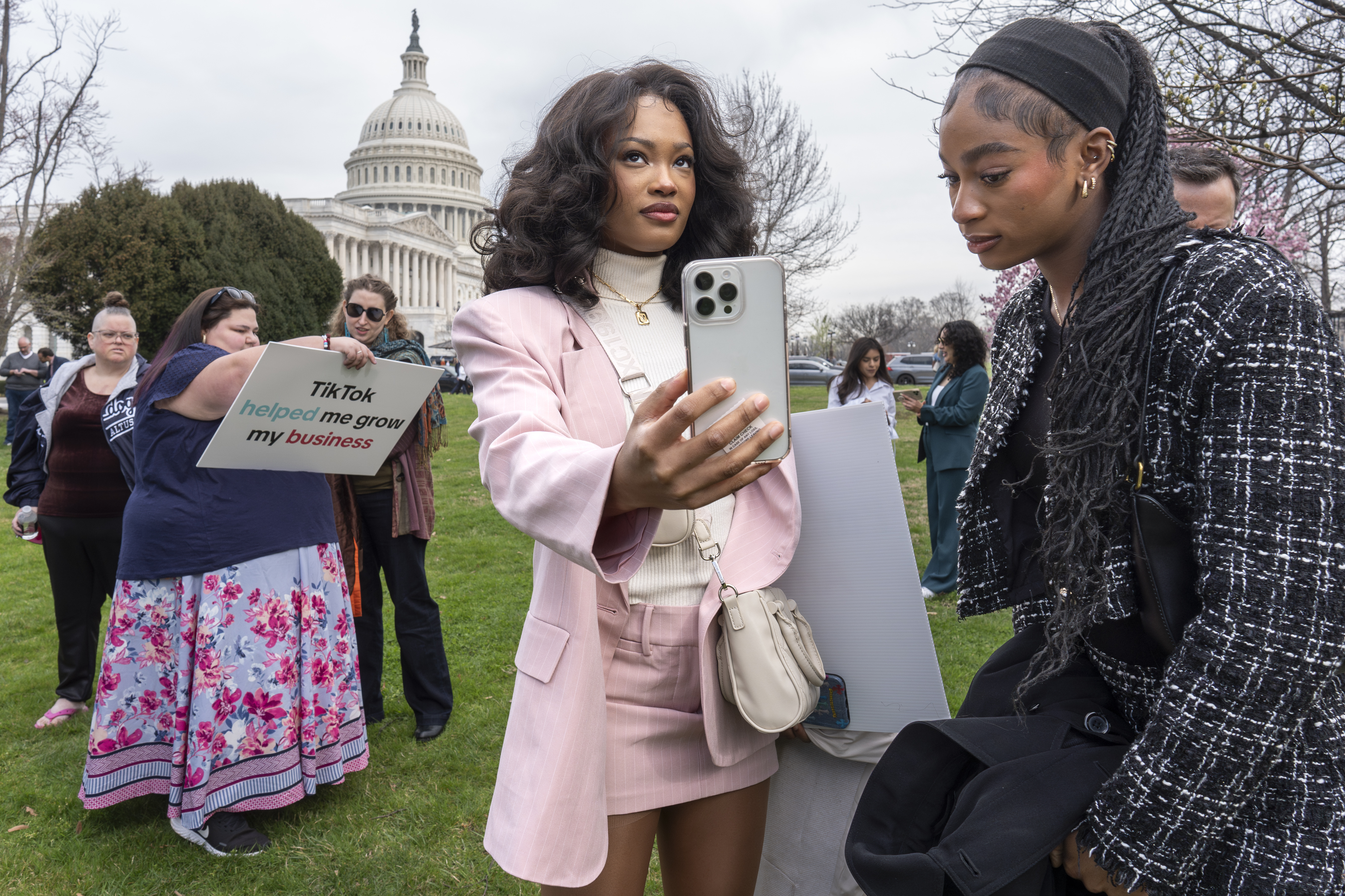 Devotees of TikTok, Mona Swain, center, and her sister, Rachel Swain, right, both of Atlanta, monitor voting at the Capitol in Washington, as the House passed a bill that would lead to a nationwide ban of the popular video app if its China-based owner doesn't sell, Wednesday, March 13