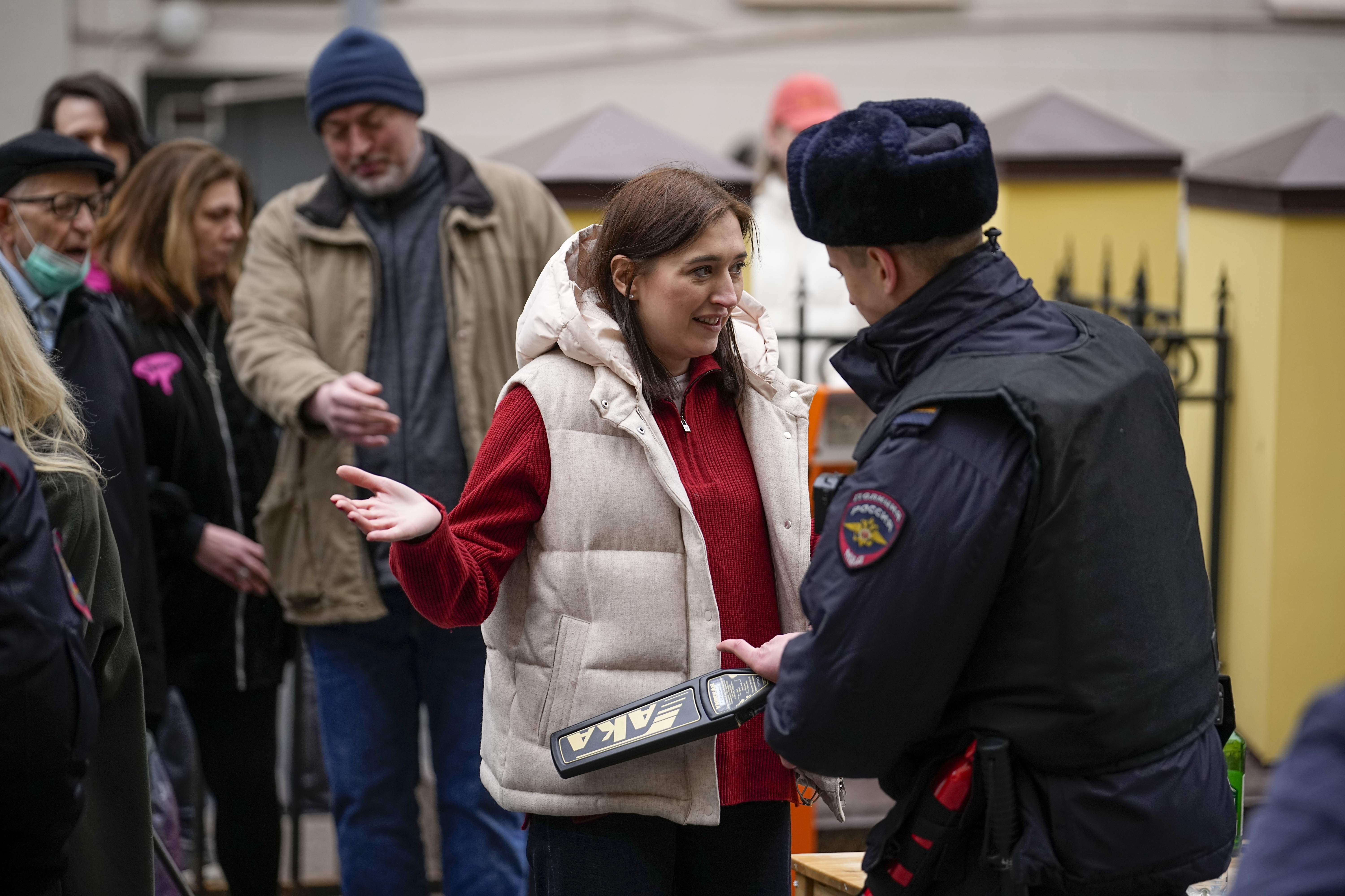 A police officer checks voters queuing at a polling station at noon local time in Moscow, Russia, on Sunday, March 17