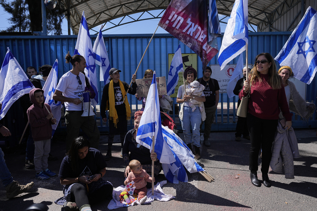 Israelis block the entrance to UNWRA, the main U.N. agency providing aid in the Gaza Strip, during a protest in Jerusalem, Wednesday, March 20, 2024. The UNRWA agency is reeling from allegations that 12 of its 13,000 Gaza staff members participated in the Oct. 7 Hamas attacks in southern Israel. (AP Photo/Ohad Zwigenberg)