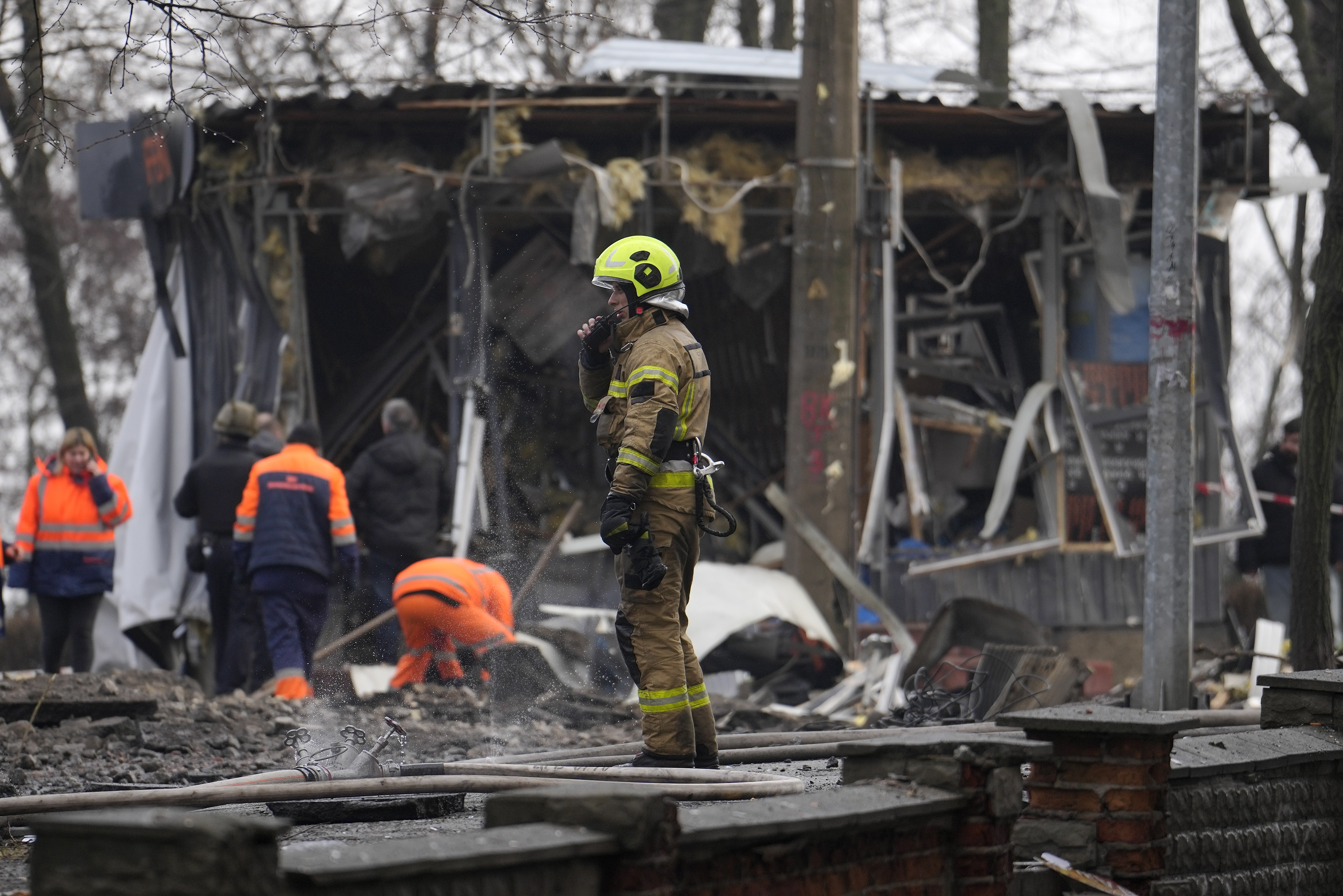 A firefighter stands amongst the debris after a Russian attack in Kyiv