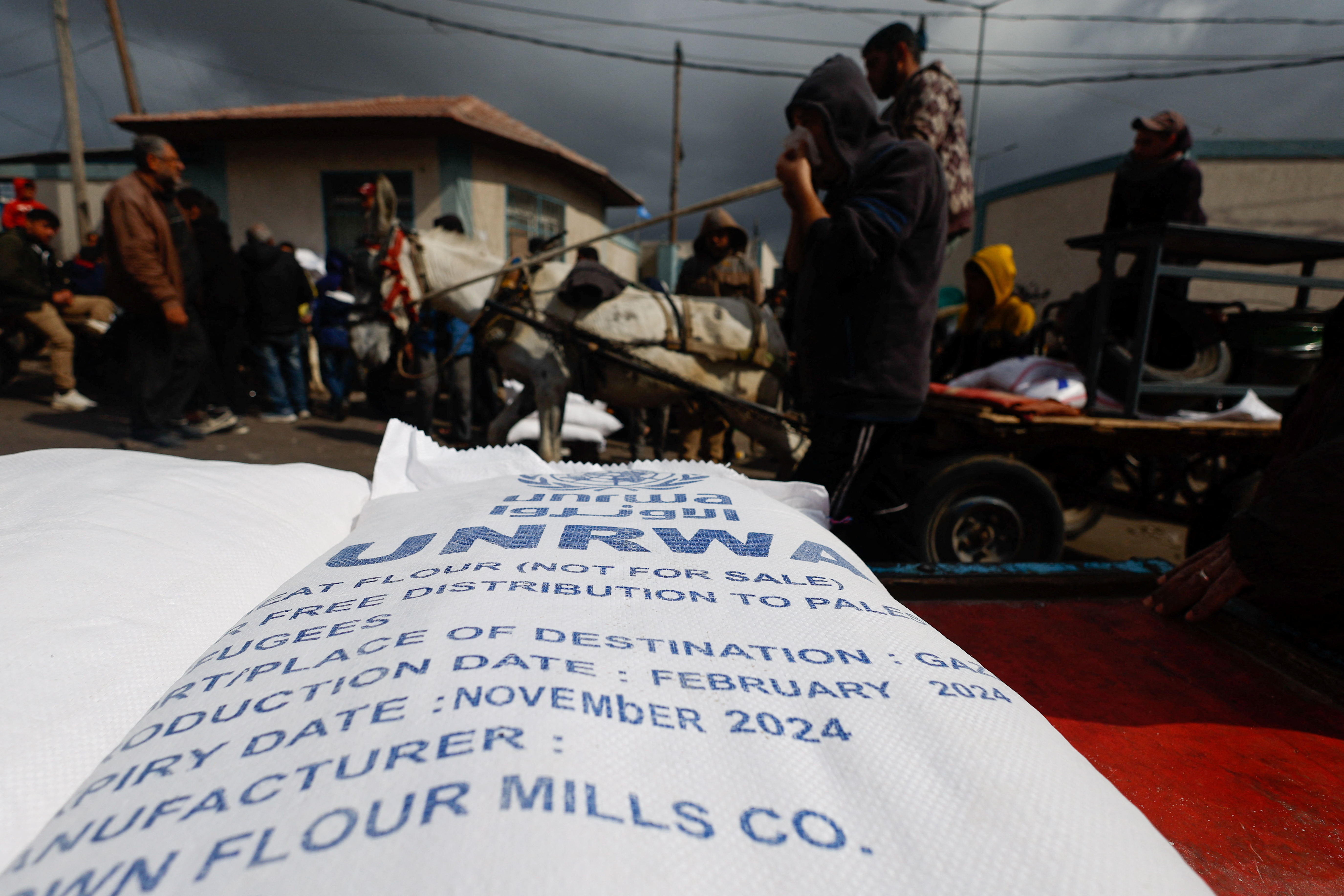 Displaced Palestinians wait to receive United Nations Relief and Works Agency (UNRWA) aid