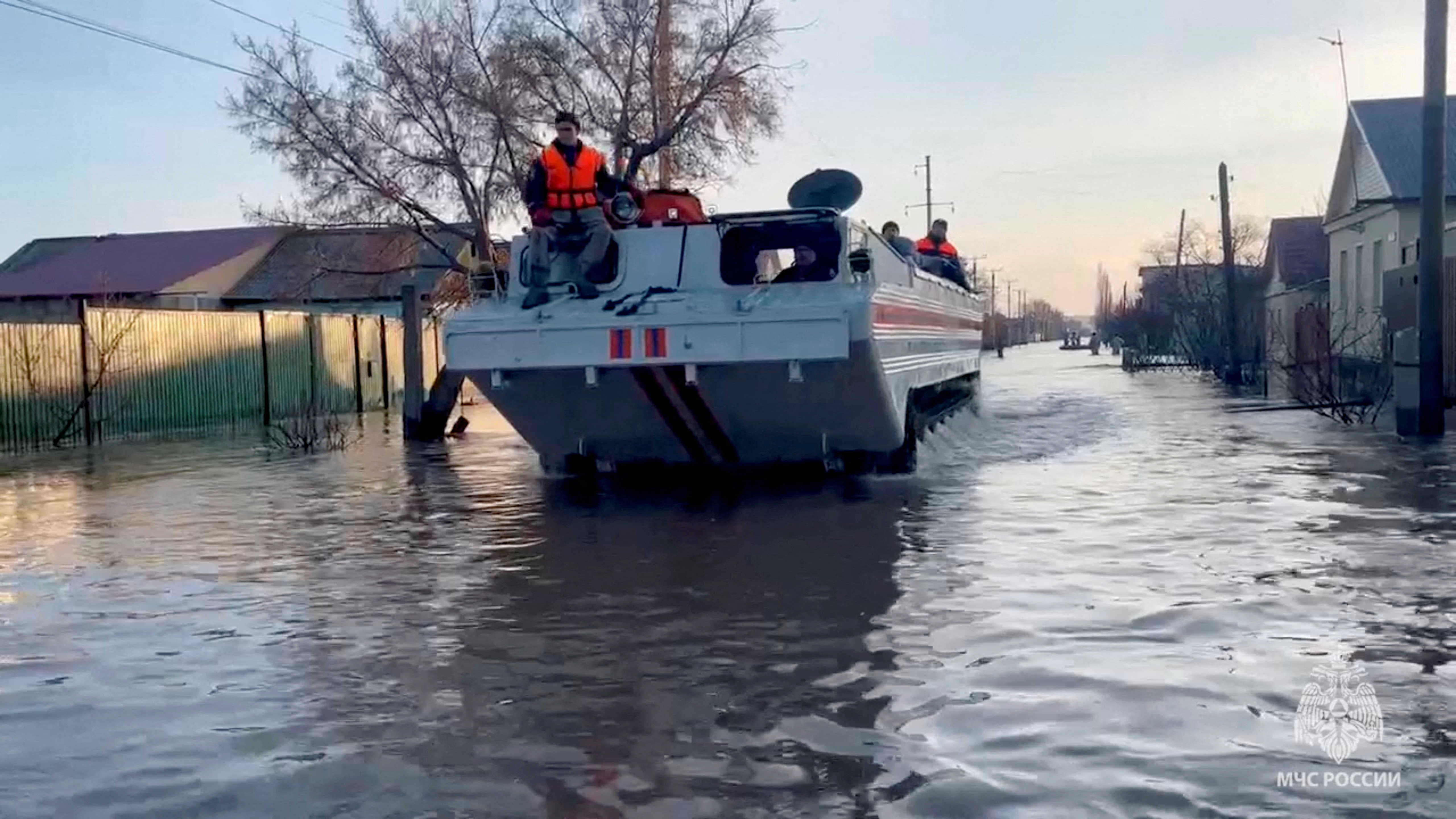 Rescuers search for residents to evacuate as they drive in a flooded residential area in the city of Orsk, Russia, April 6, 2024