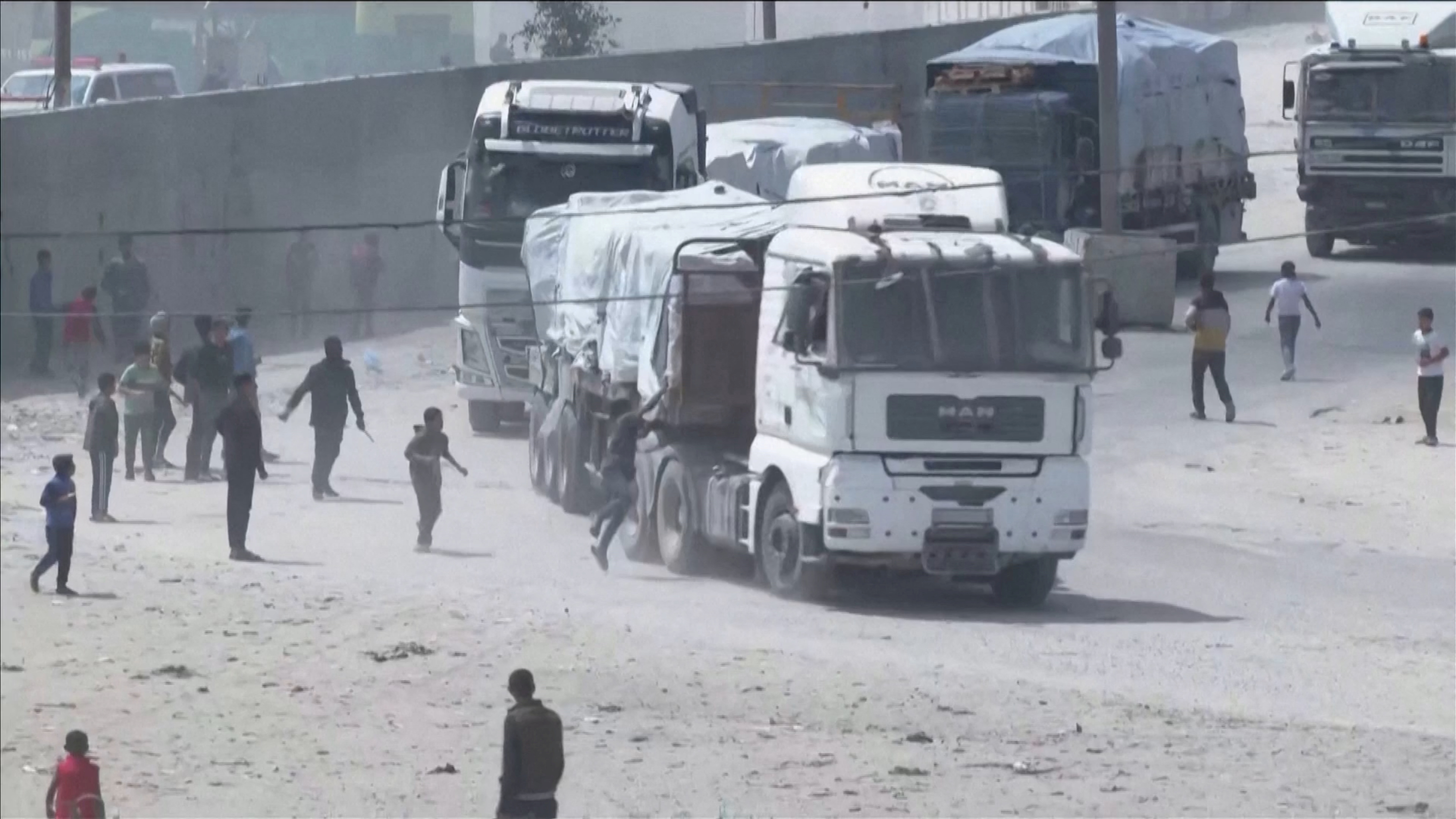 People chase a convoy of aid trucks driving into Gaza from Rafah crossing, April 9, 2024. [Reuters]
