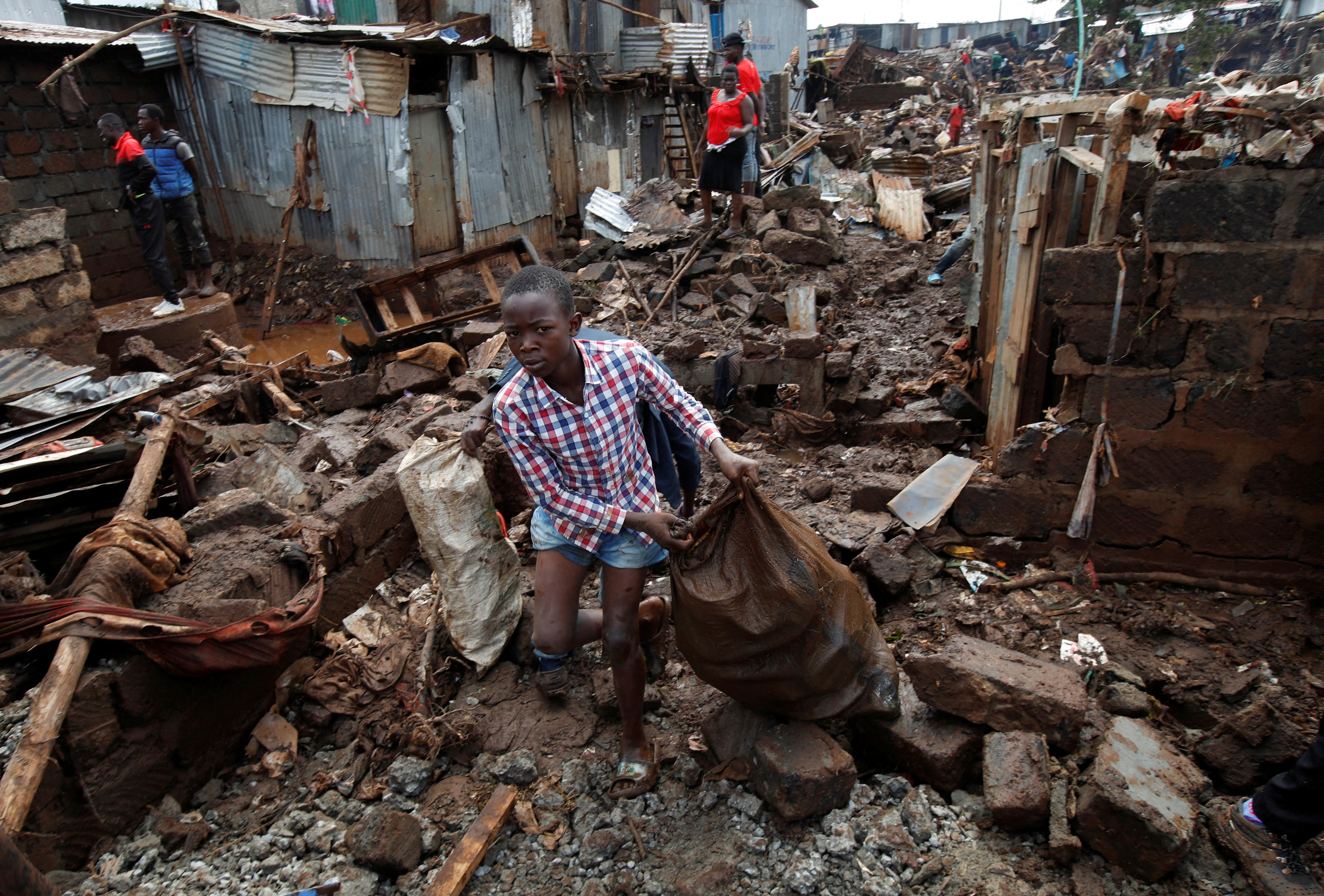 Residents sift through the rubble as they recover their belongings after the Nairobi river burst its banks and destroyed their homes within the Mathare Valley settlement in Nairobi