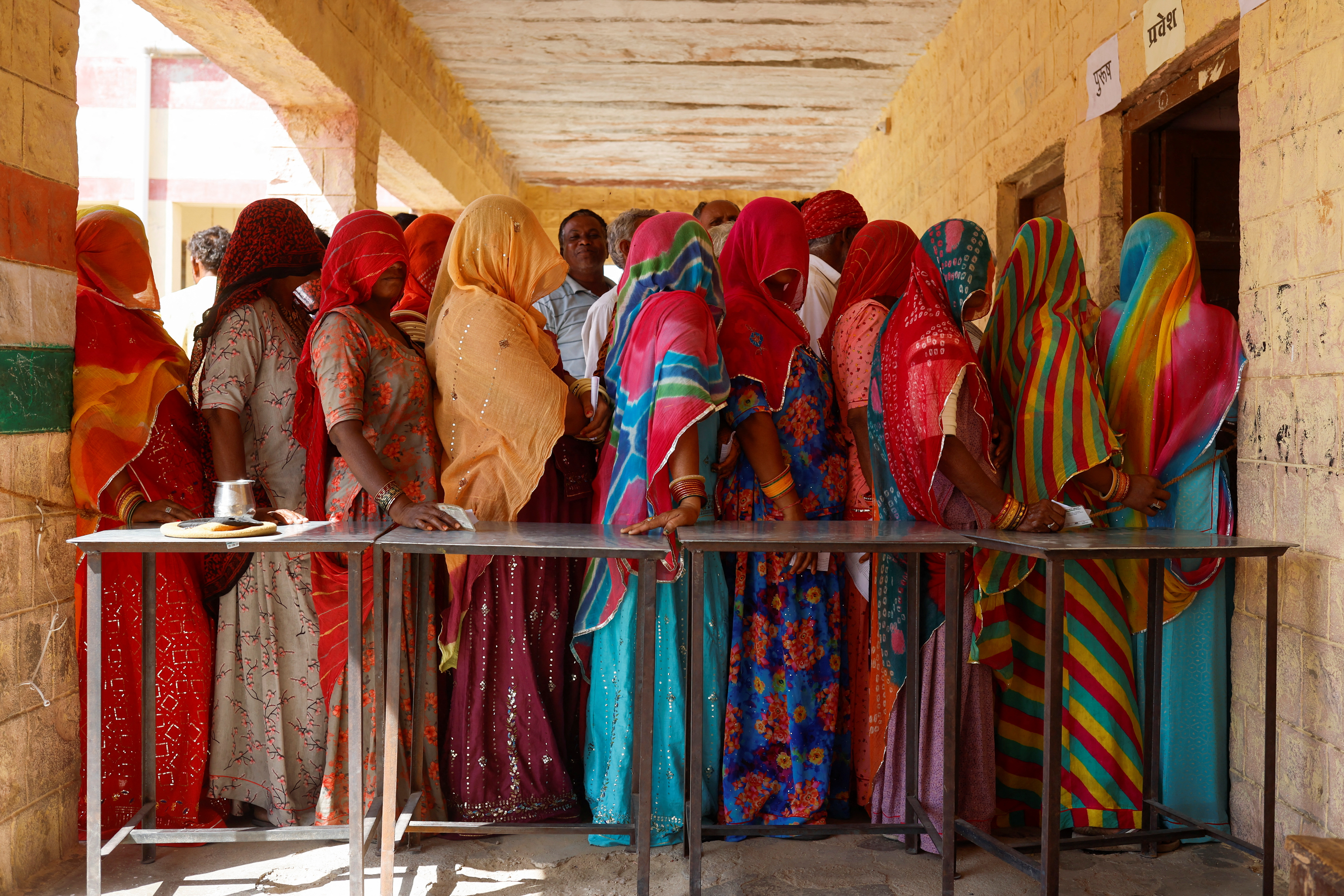 People queue to vote at a polling station during the second phase of the general elections, in Barmer, Rajasthan, India