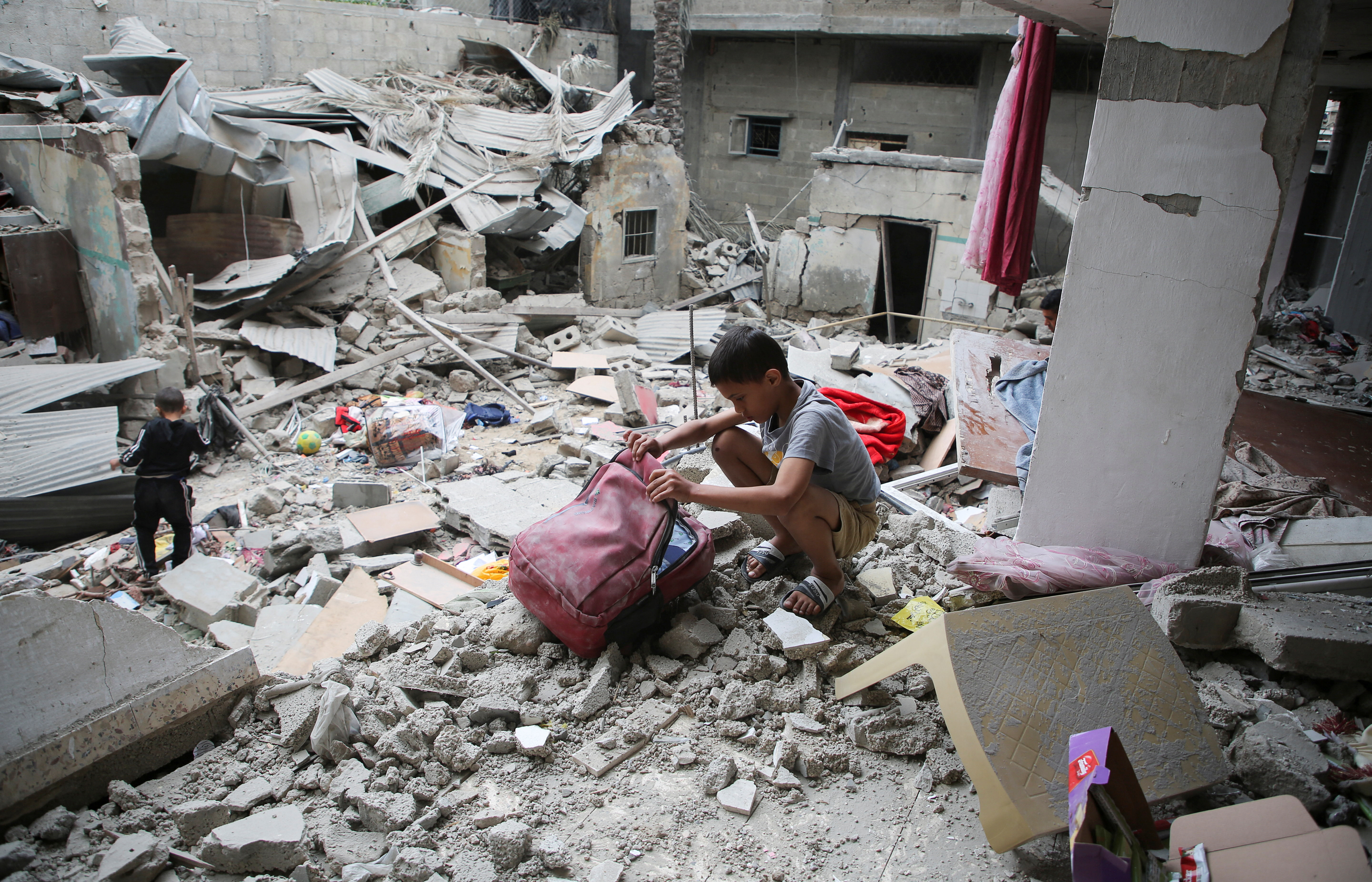 Palestinian children inspect the site of an Israeli strike on a house