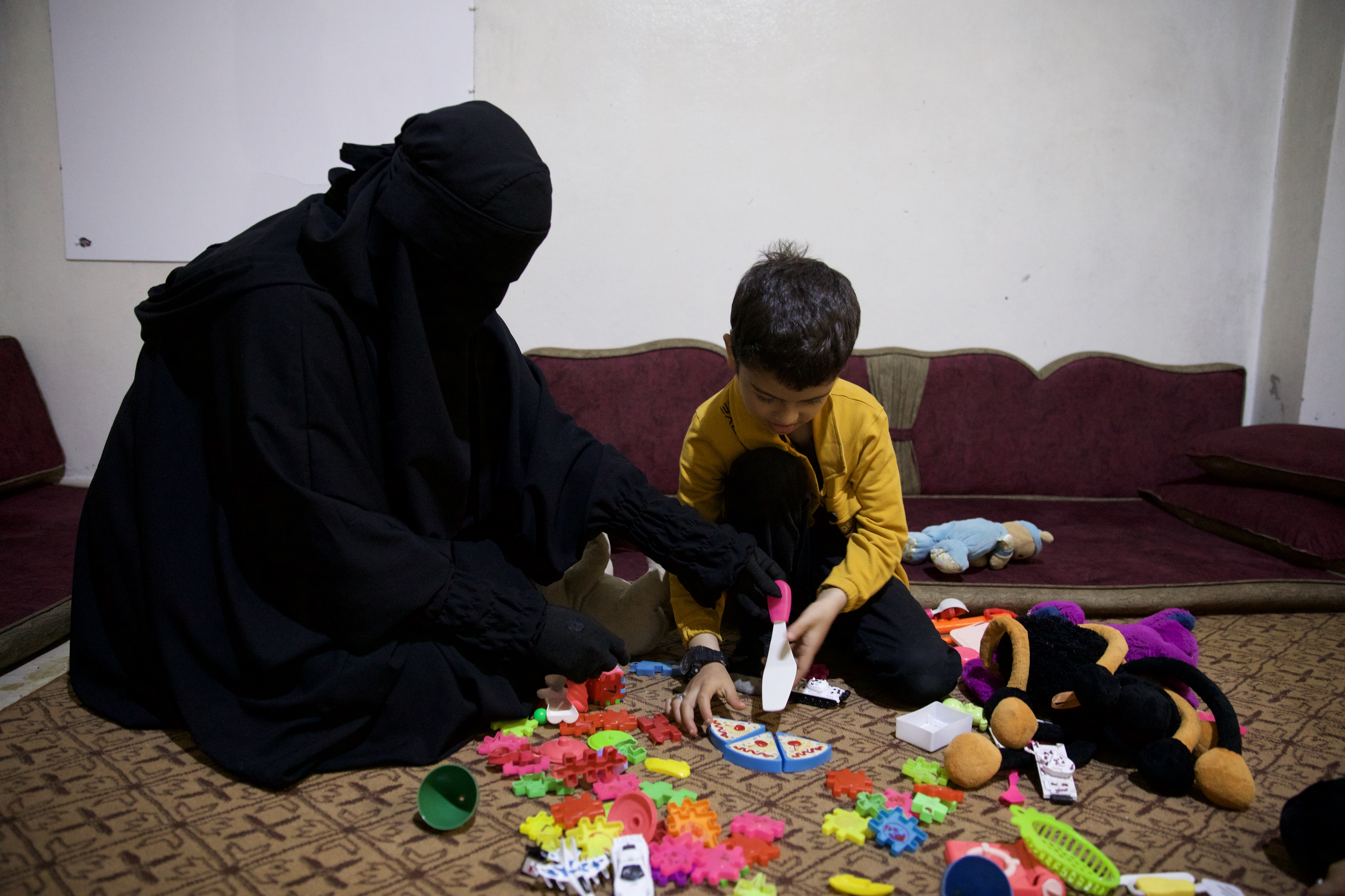 Fatima plays with Aslan in their living room in Idlib