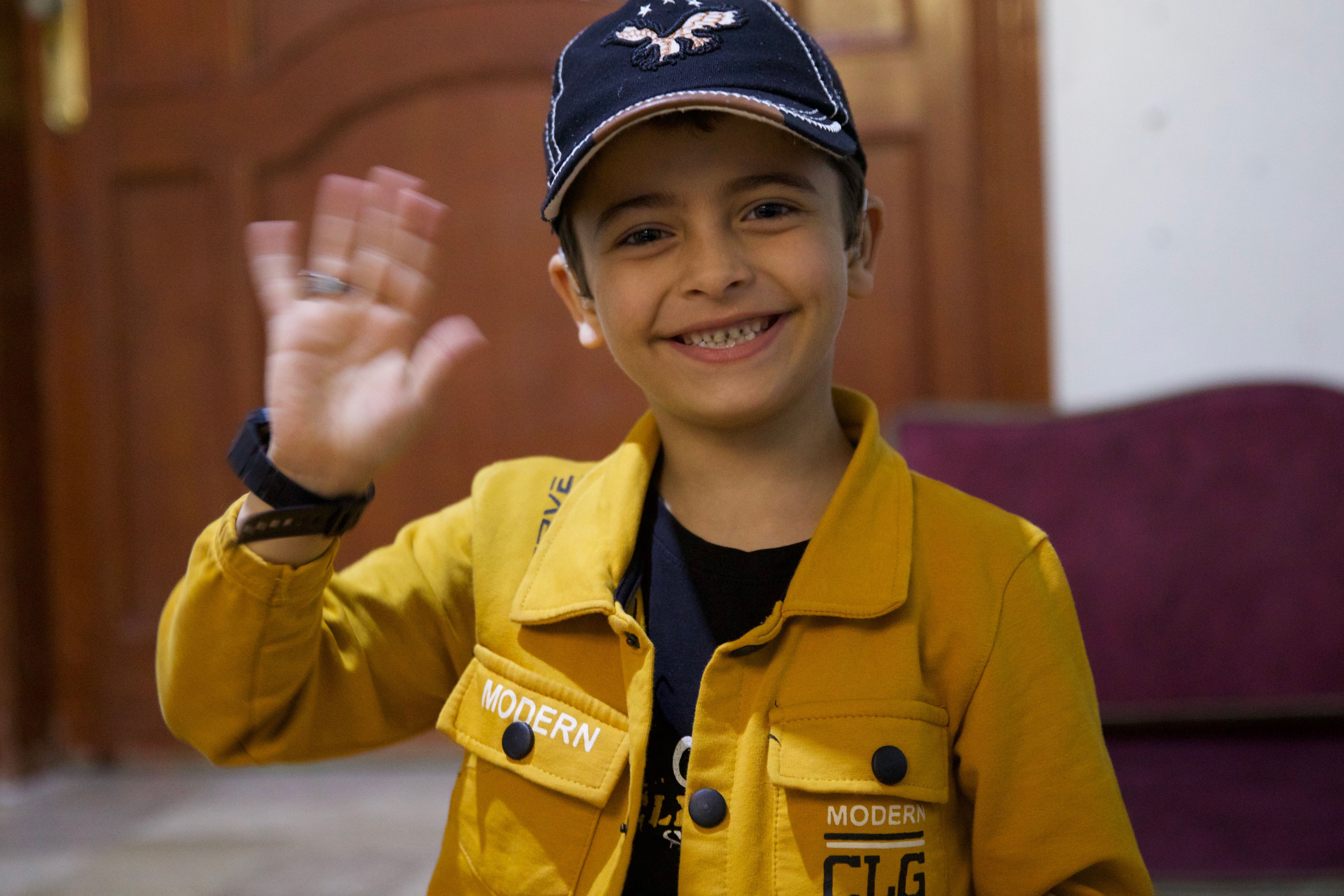 Aslan smiles and waves