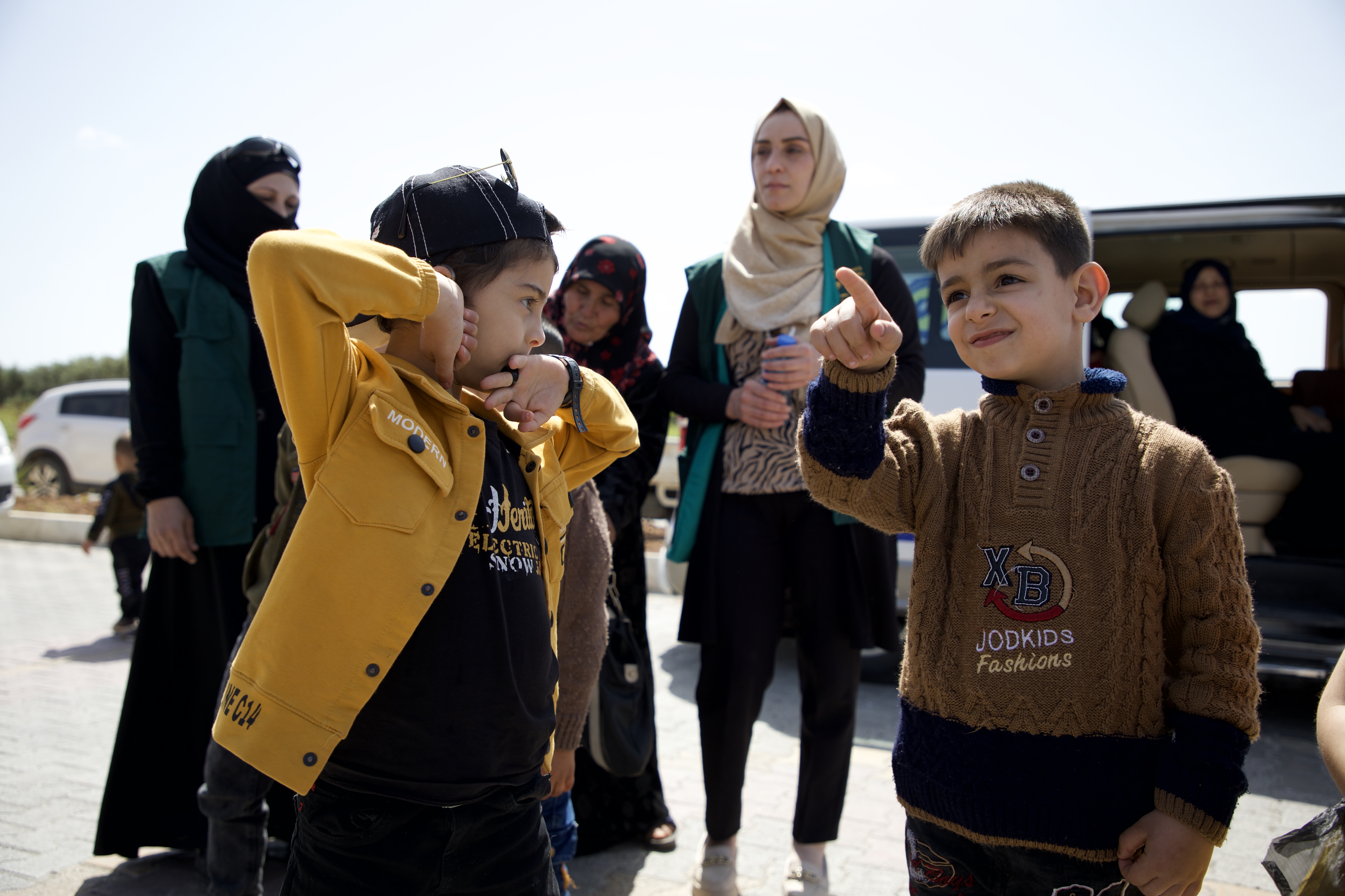 Aslan talks to a little boy in a brown sweater