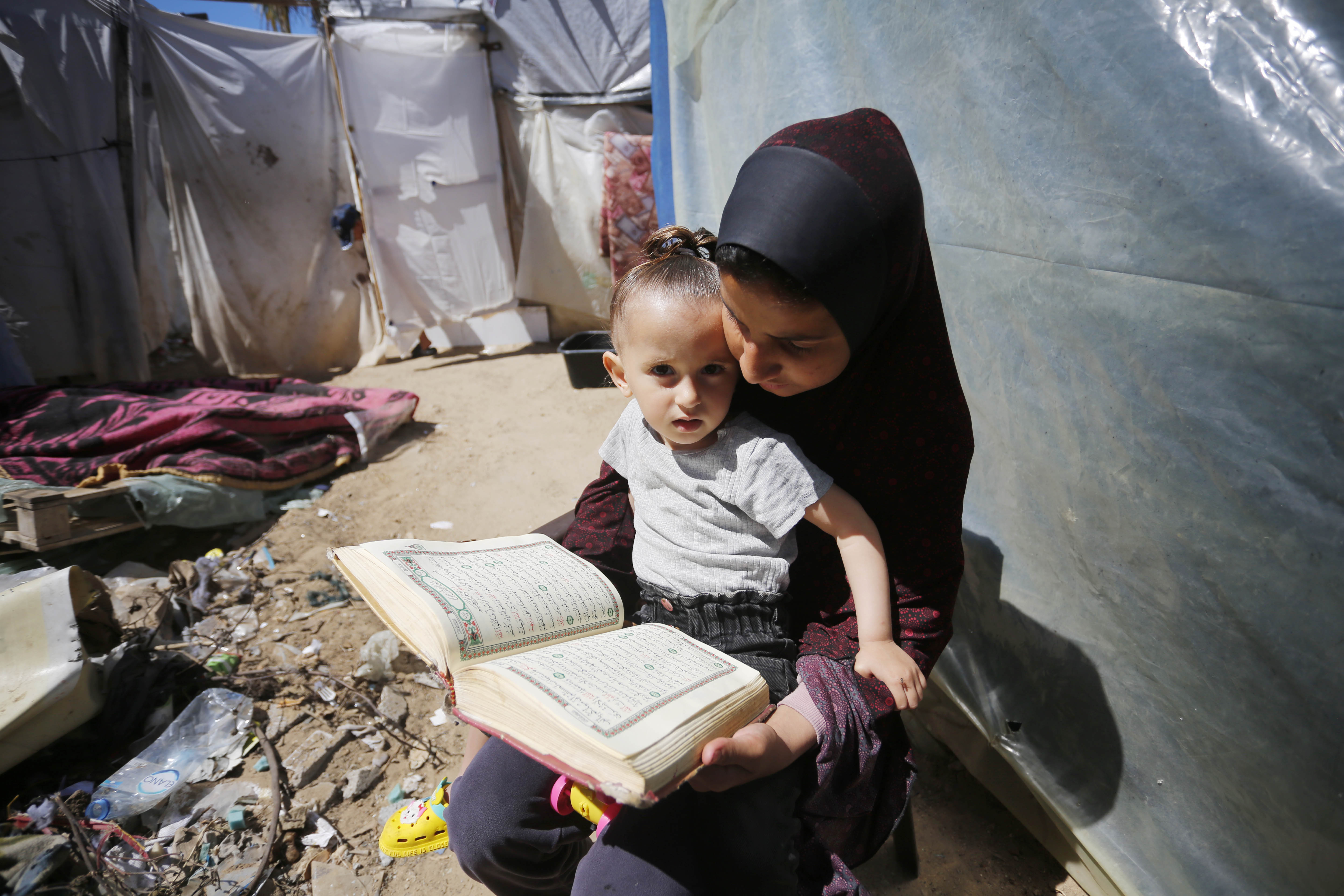 Palestinians living in tents spend the last days of Ramadan reading the Holy Quran
