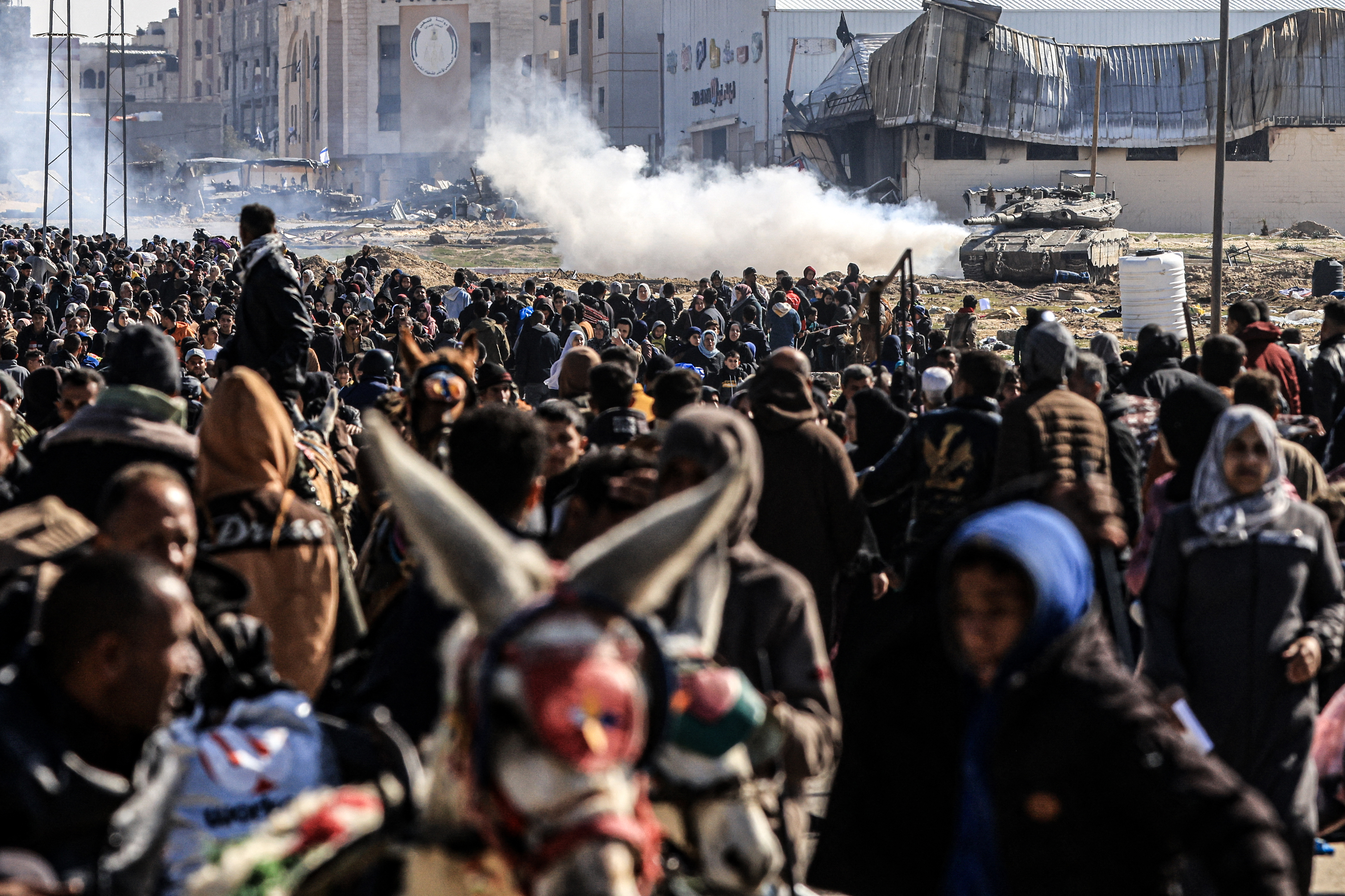 An Israeli tank rolls along a position as Palestinians flee Khan Younis in the southern Gaza Strip on January 26