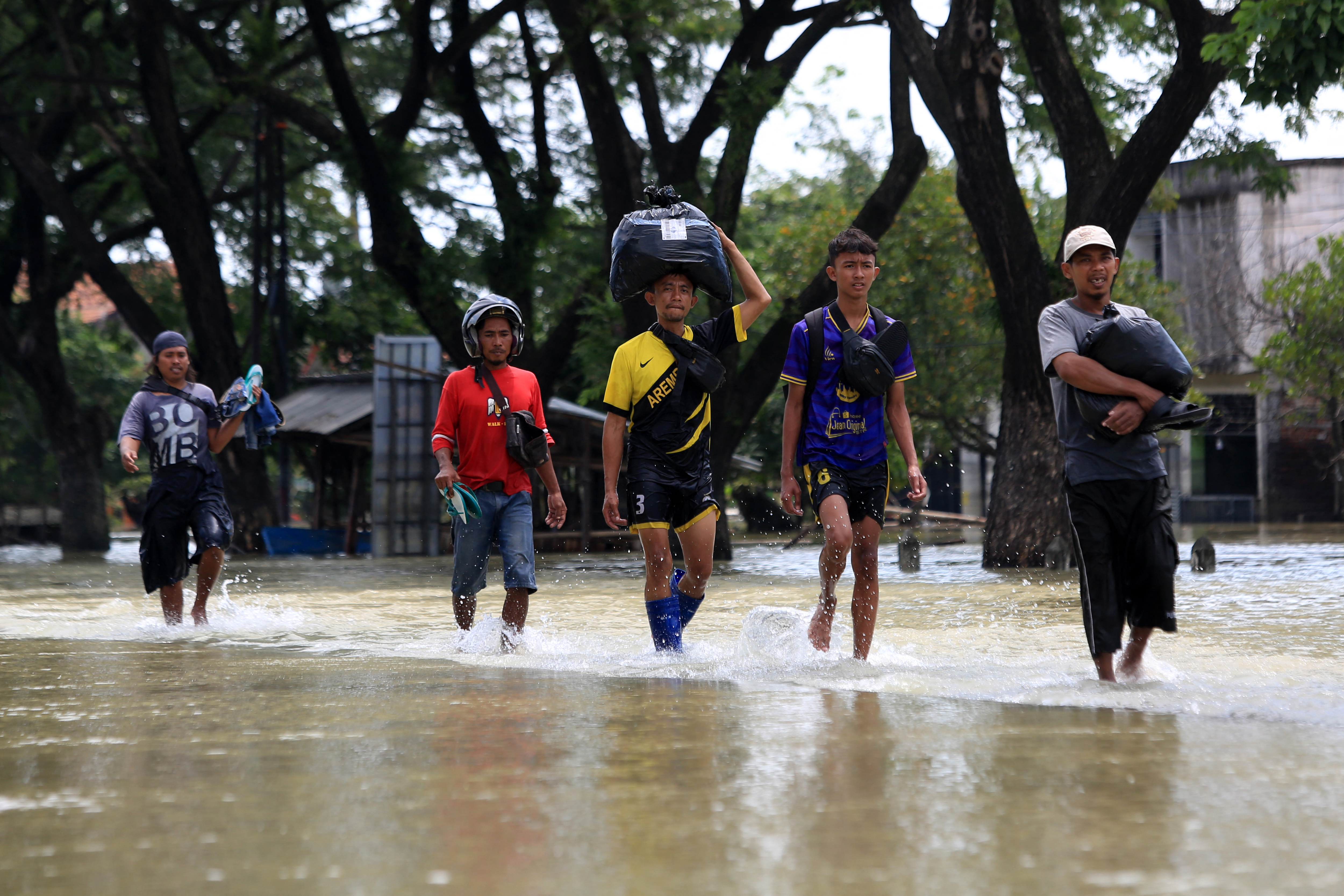 Local residents carry they belongings in a flooded street