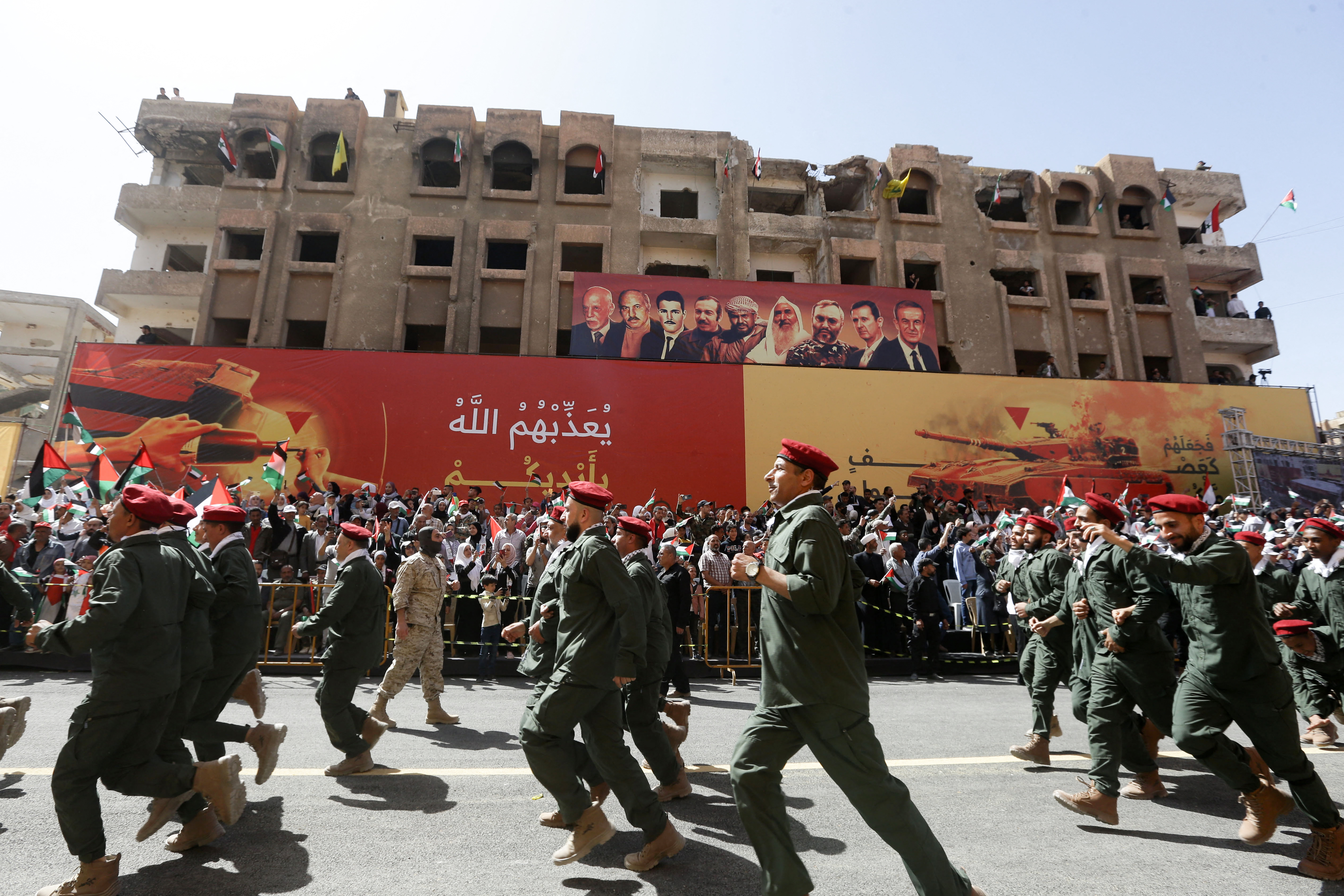 Palestinian members of a pro-Syrian government squad, take part in a military parade to mark the annual Quds (Jerusalem) Day commemorations, in the Yarmouk refugee camp in Damascus