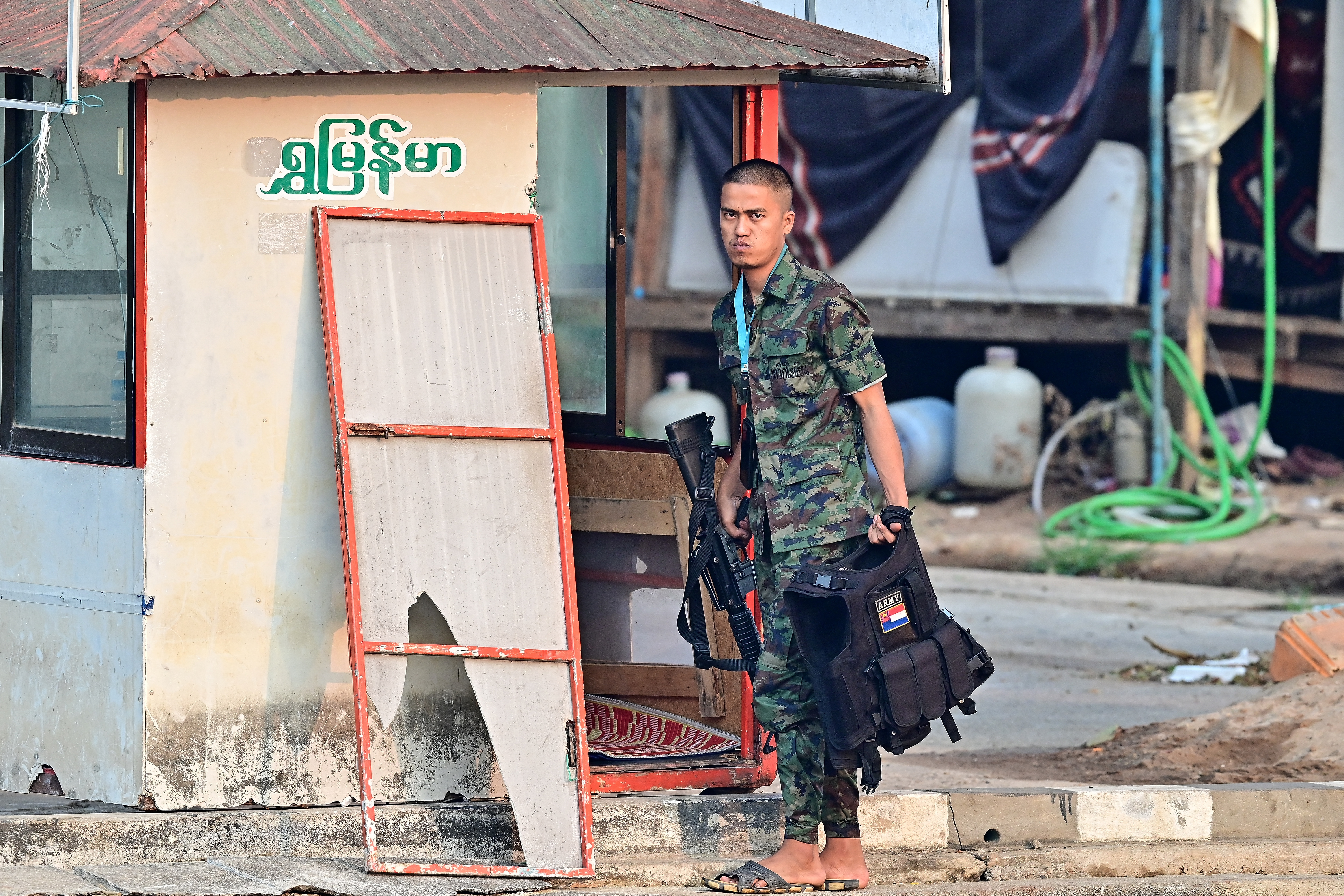 A Myanmar militia member with his weapon, He is standing on the Myanmar side of the border, across the river from Thailand