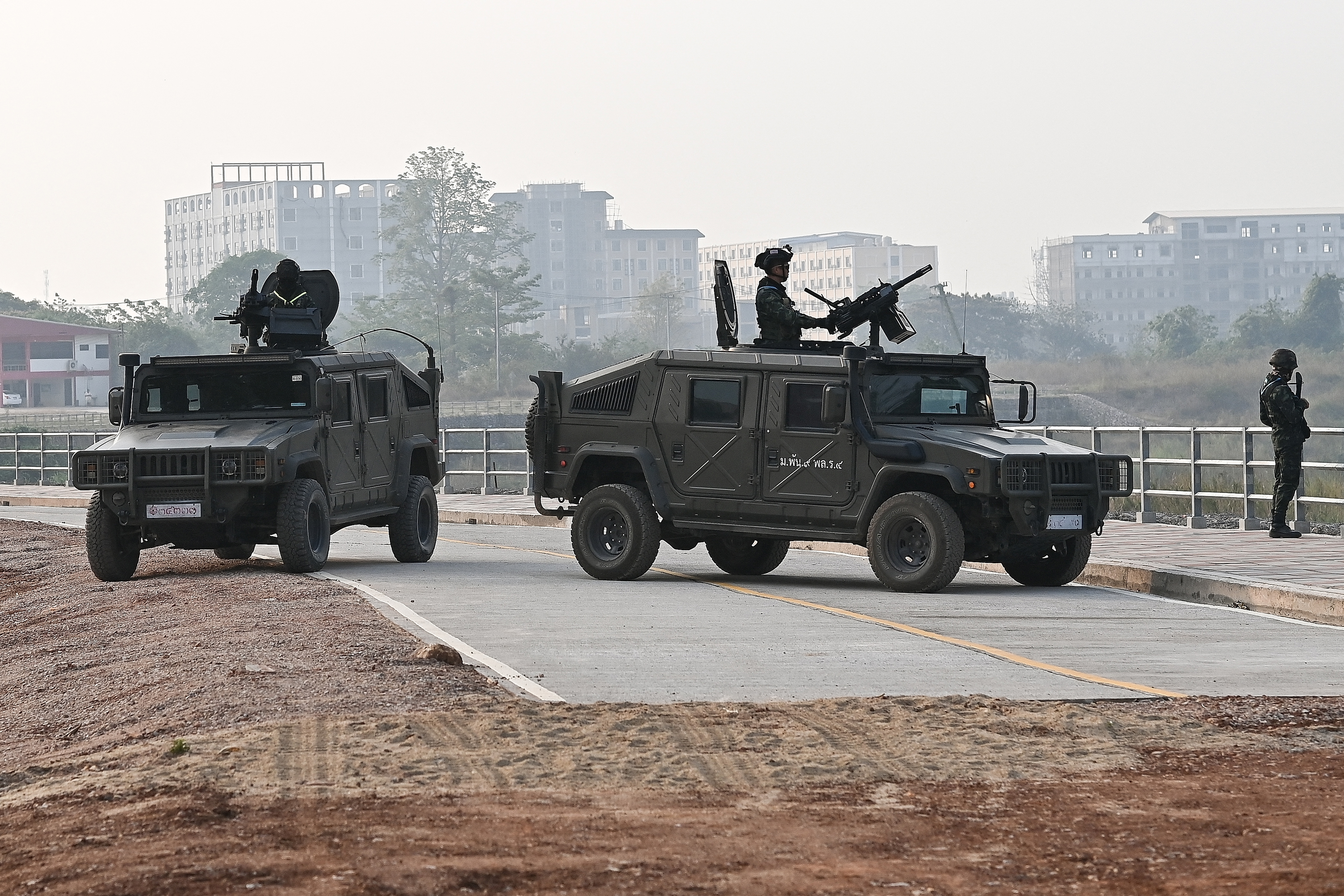 Thai military personnel keep watch atop armoured vehicles along the Moei river on the Thai side, next to the 2nd Thai-Myanmar Friendship Bridge, in Thailand's Mae Sot district on April 12, 2024. Myanmar troops have withdrawn from their positions in a trade hub near the Thai border, a spokesman for the junta said, confirming reports from an ethnic armed group that has been battling the military for days. (Photo by MANAN VATSYAYANA / AFP)