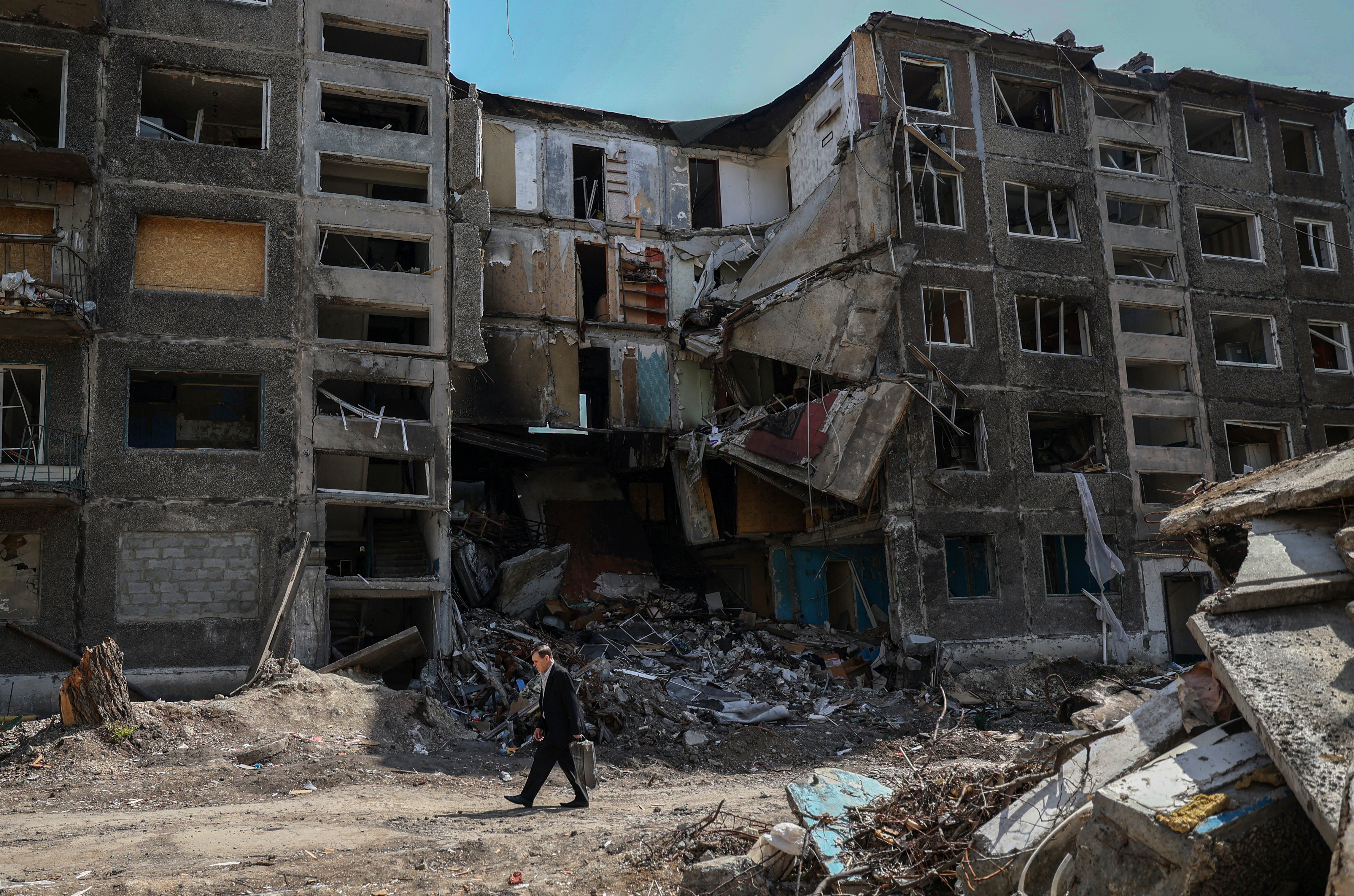 A local resident walks past heavily damaged buildings in the town of Selydove, Donetsk region, on April 12, 2024, amid the Russian invasion of Ukraine. (Photo by Anatolii STEPANOV / AFP)