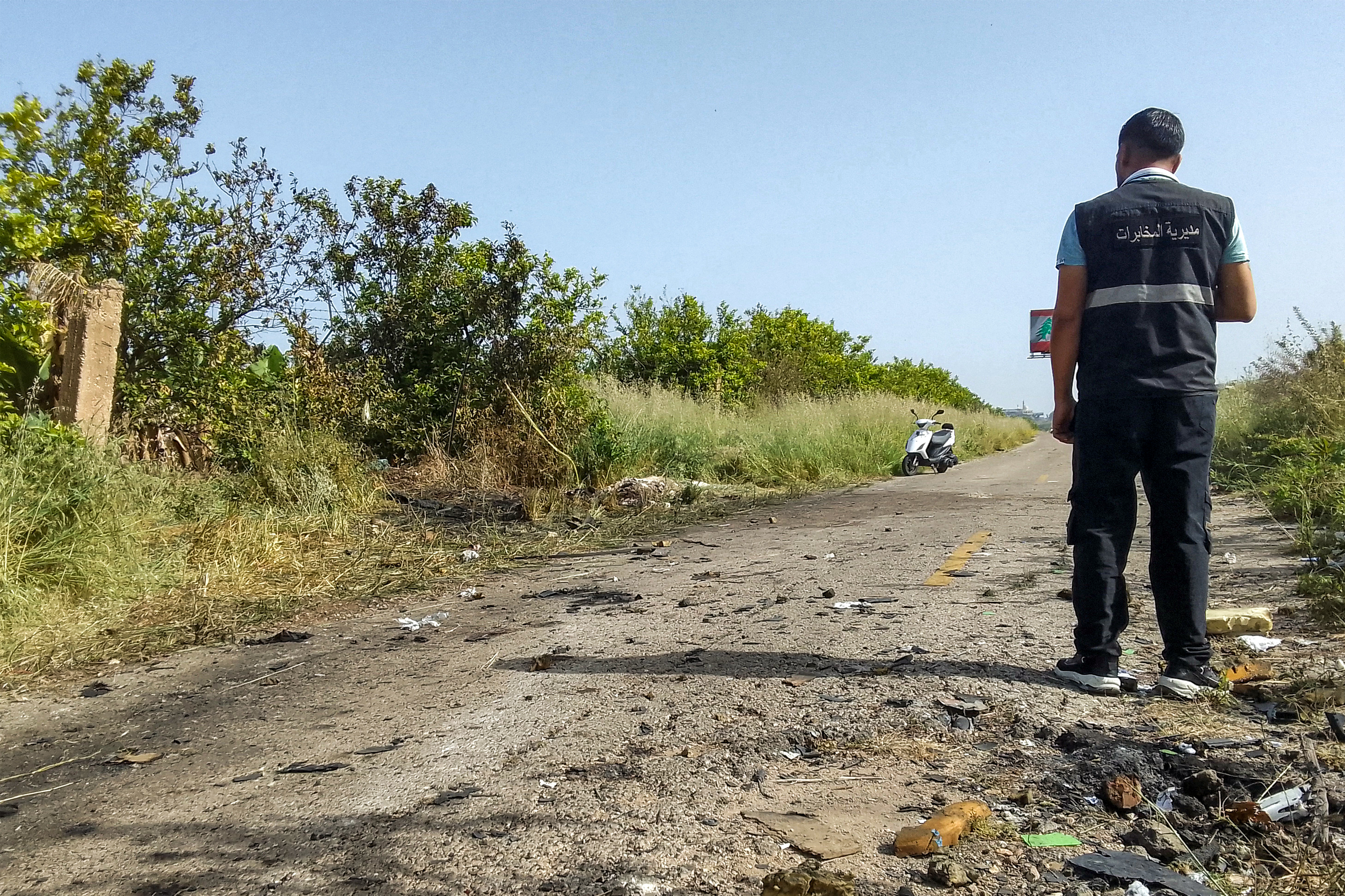A member of the Lebanese intelligence service stands at the site of an Israeli strike on a vehicle in the Adloun plain area