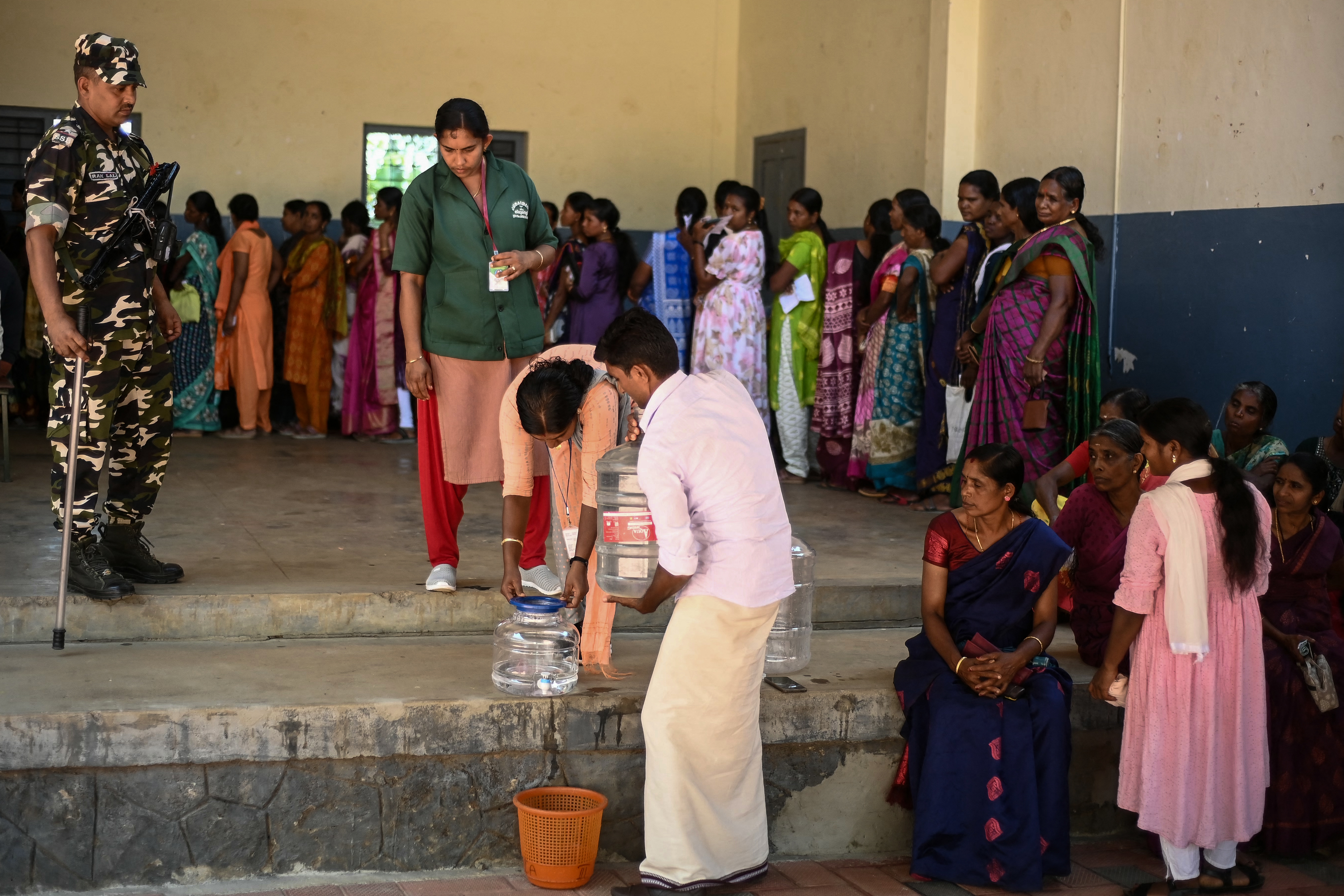 Officials arrange for drinking water at a polling station during the second phase of voting of India's general election in Wayanad district in Kerala