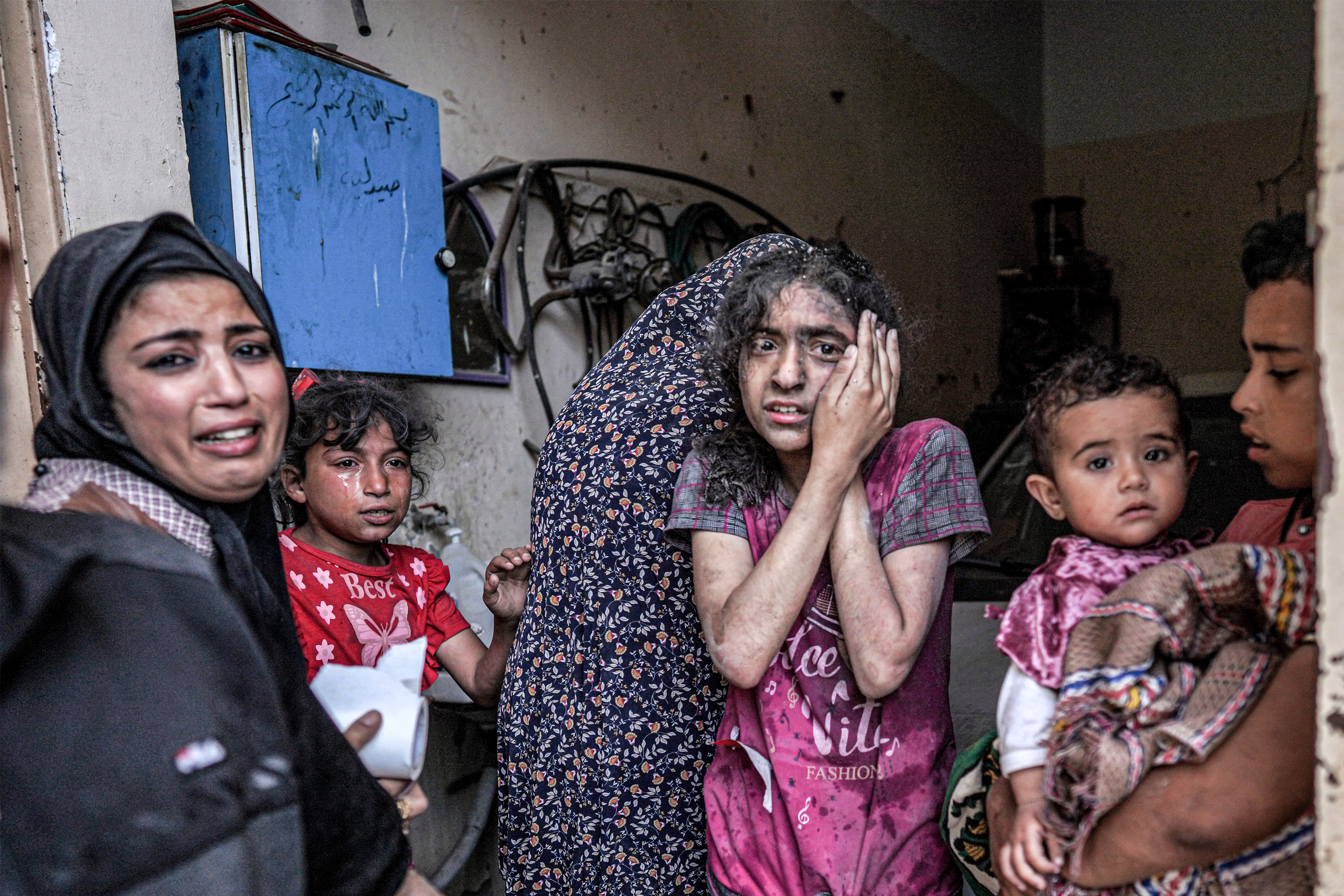 A woman and children react following Israeli bombardment in Nuseirat in the central Gaza Strip