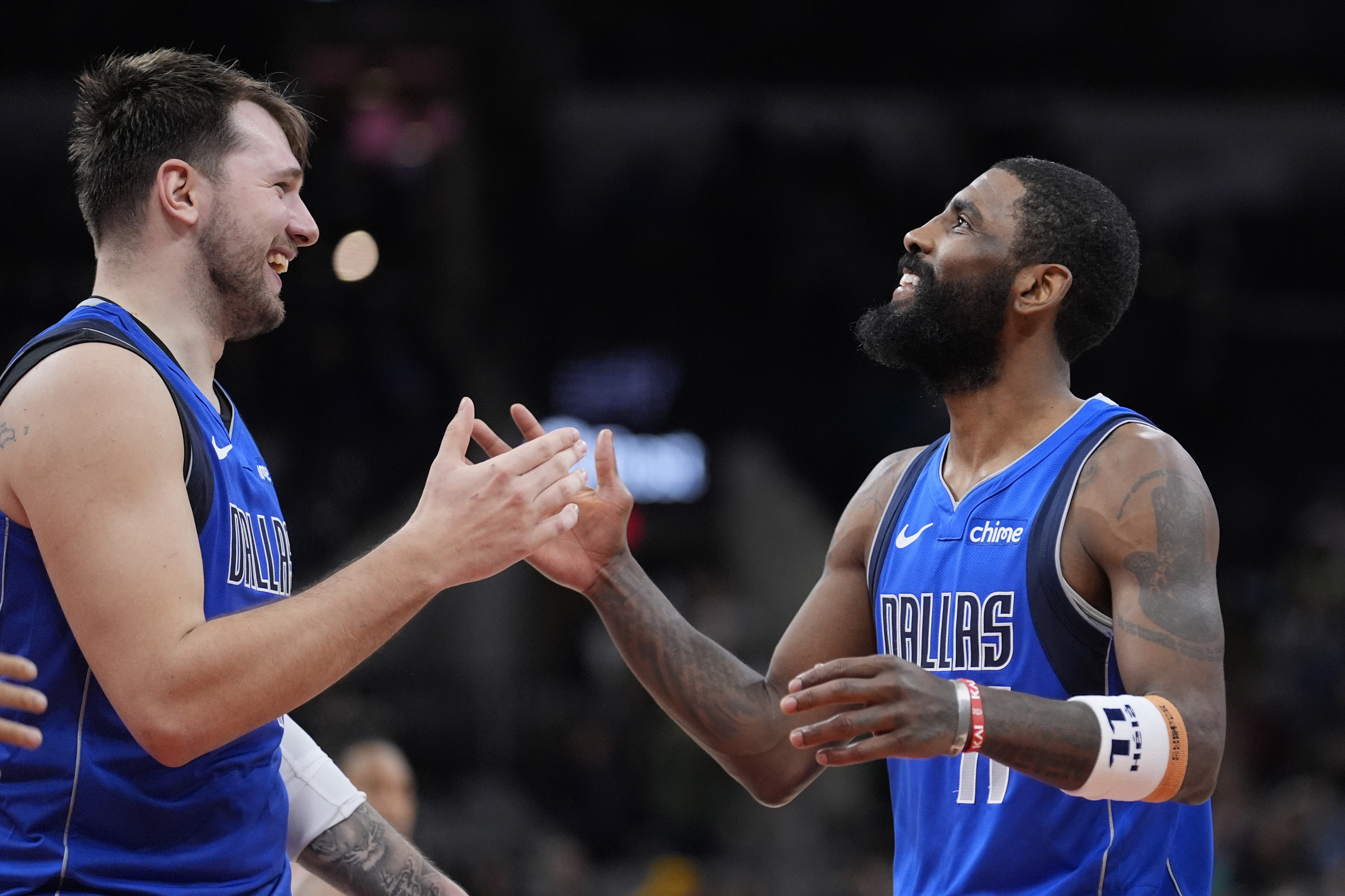 Luka Doncic and Kyrie Irving celebrate a victory.