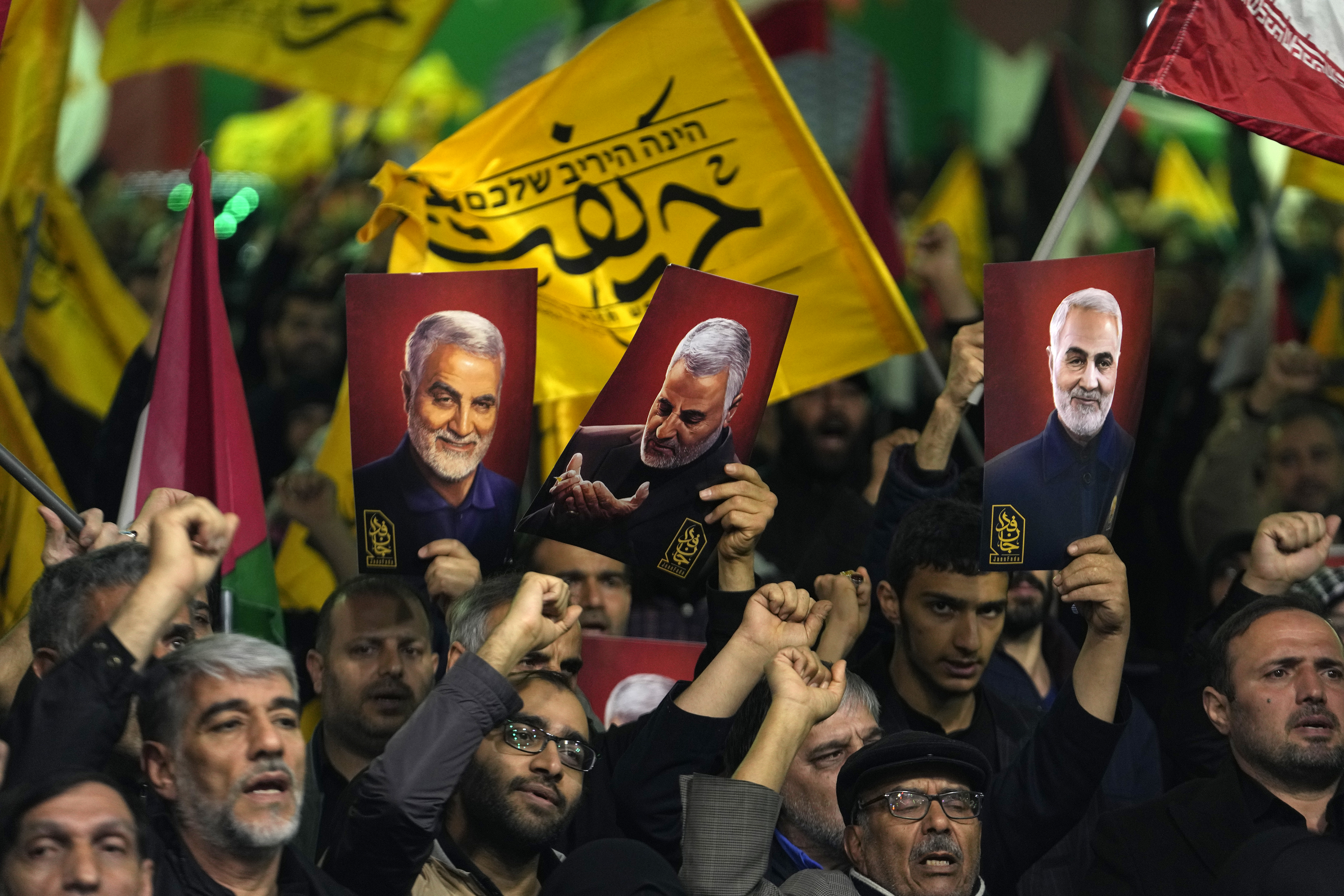 Protesters in Tehran. They are holding up posters of Iranian Revolutionary Guard Gen. Qassem Soleimani, who was killed in a US drone attack in 2020. 