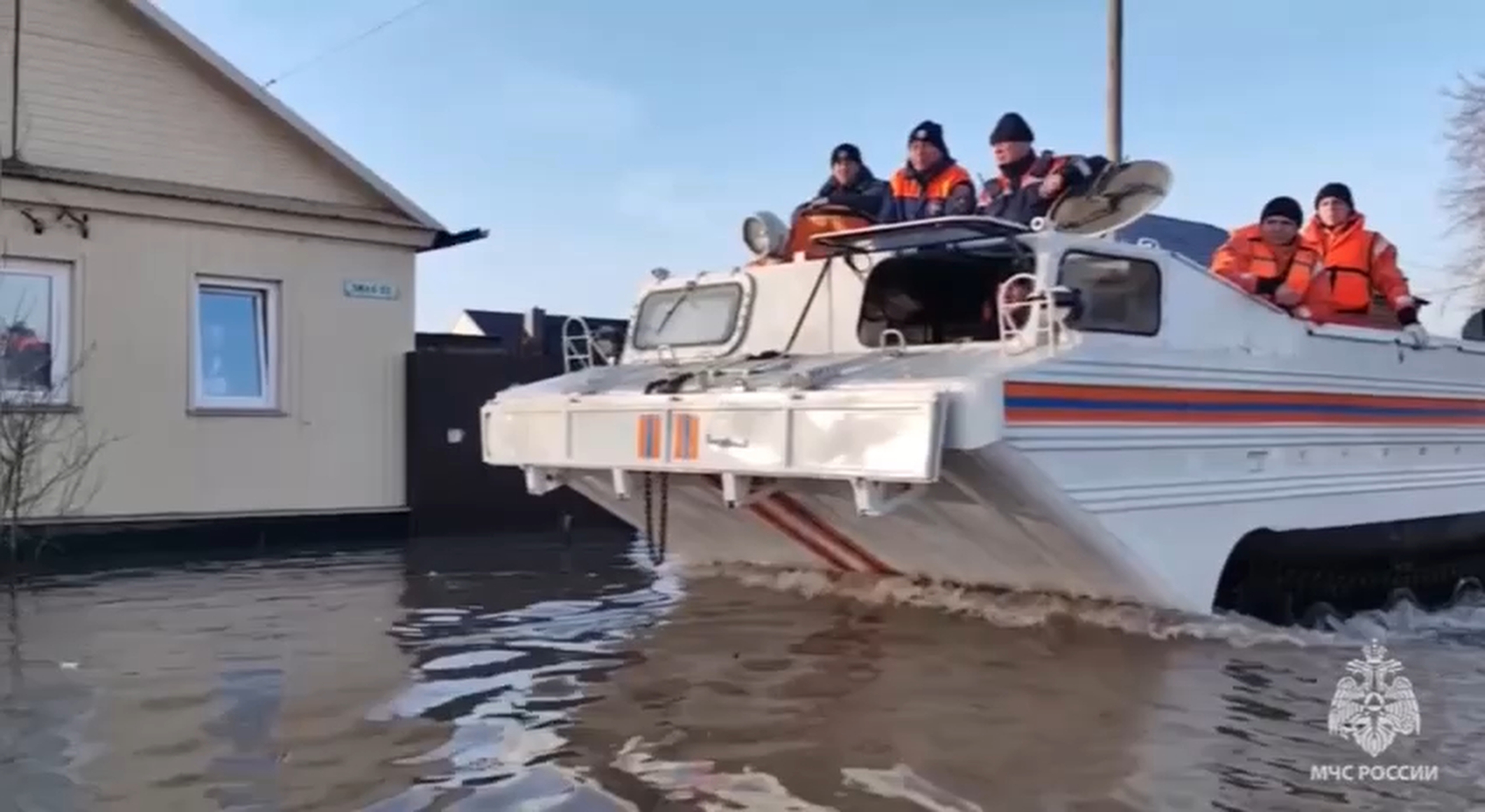 In this grab taken from a video released by the Russian Emergency Ministry Press Service on Saturday, April 6, 2024, emergency workers aboard an amphibious vehicle look to evacuate local residents after a part of a dam burst causing flooding, in Orsk, Russia.