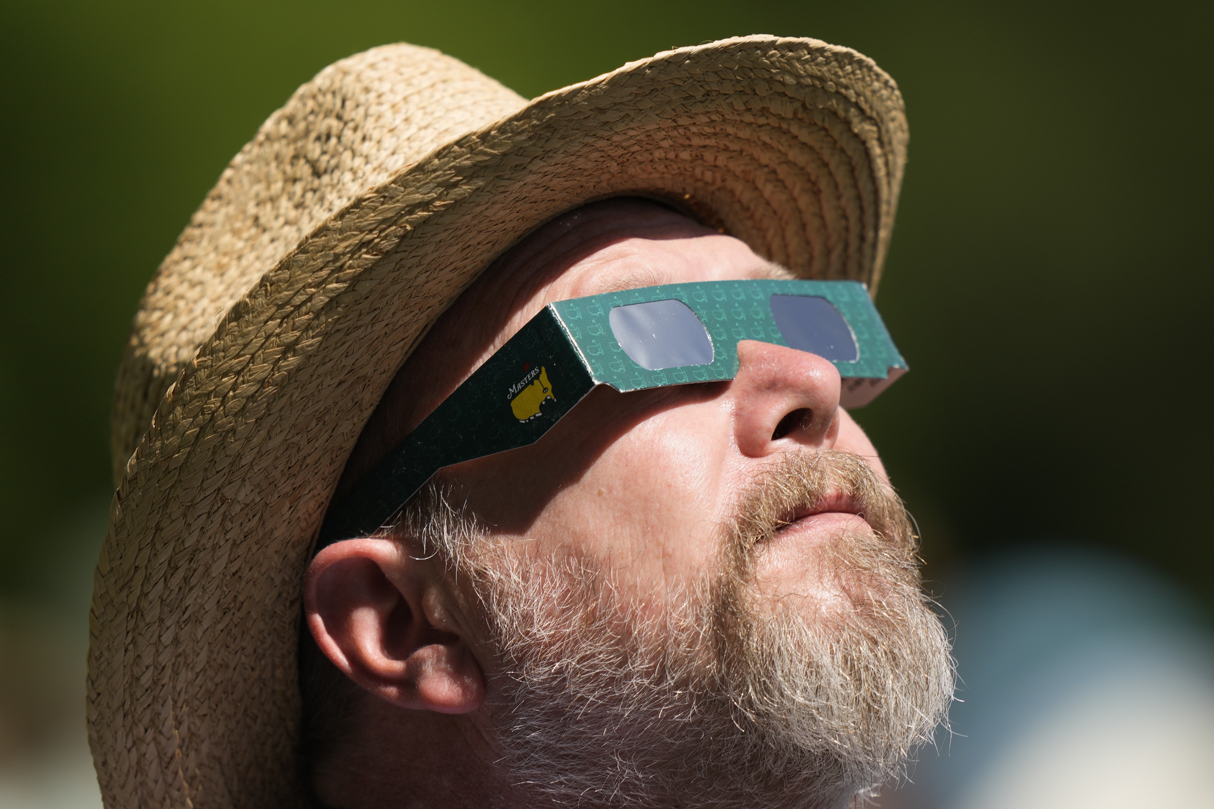 A man looks up at the sun during a solar eclipse at the Augusta National Golf Club in the US state of Georgia on April 7, 2024