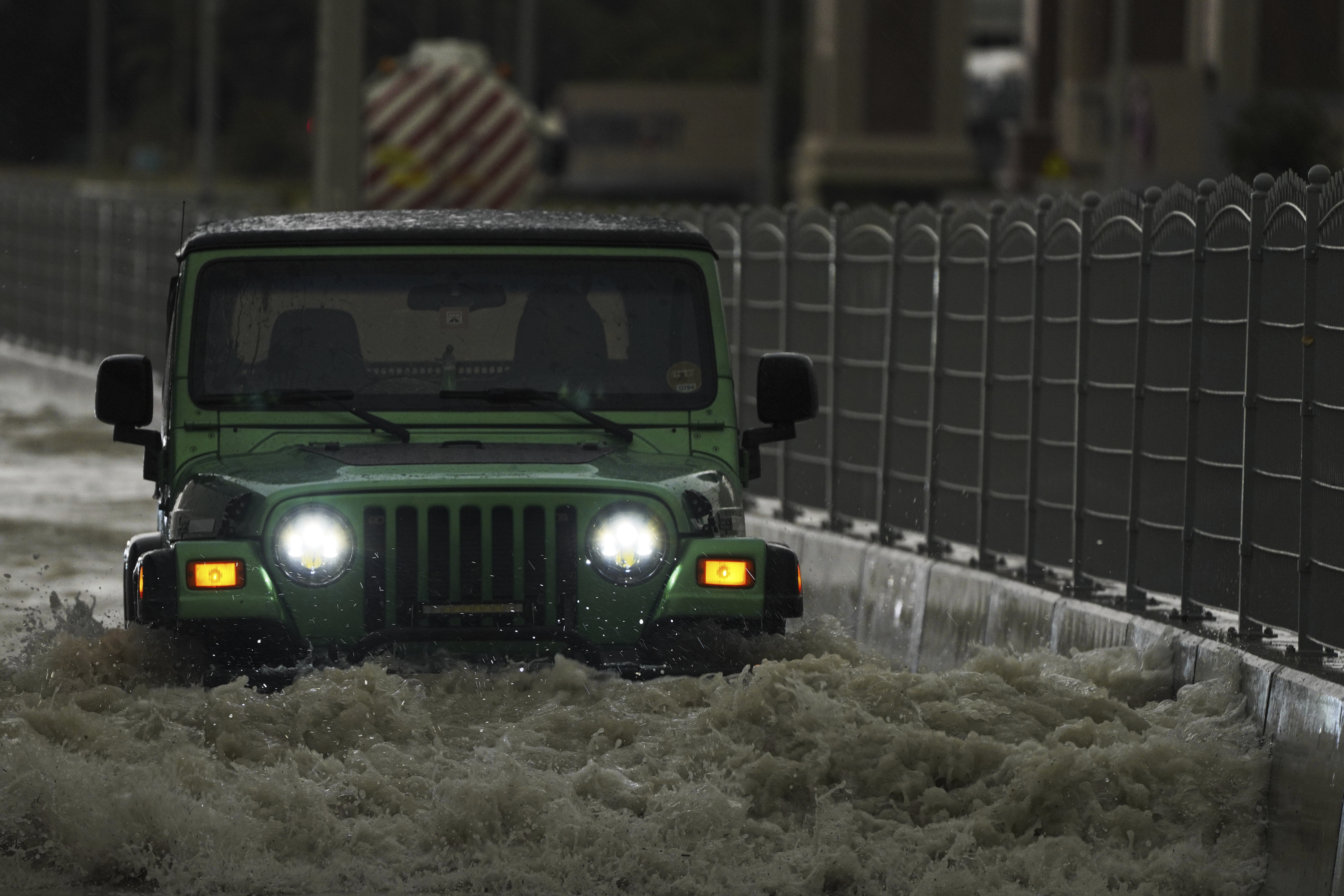 An SUV passes through standing water in Dubai, United Arab Emirates, Tuesday, April 16, 2024.