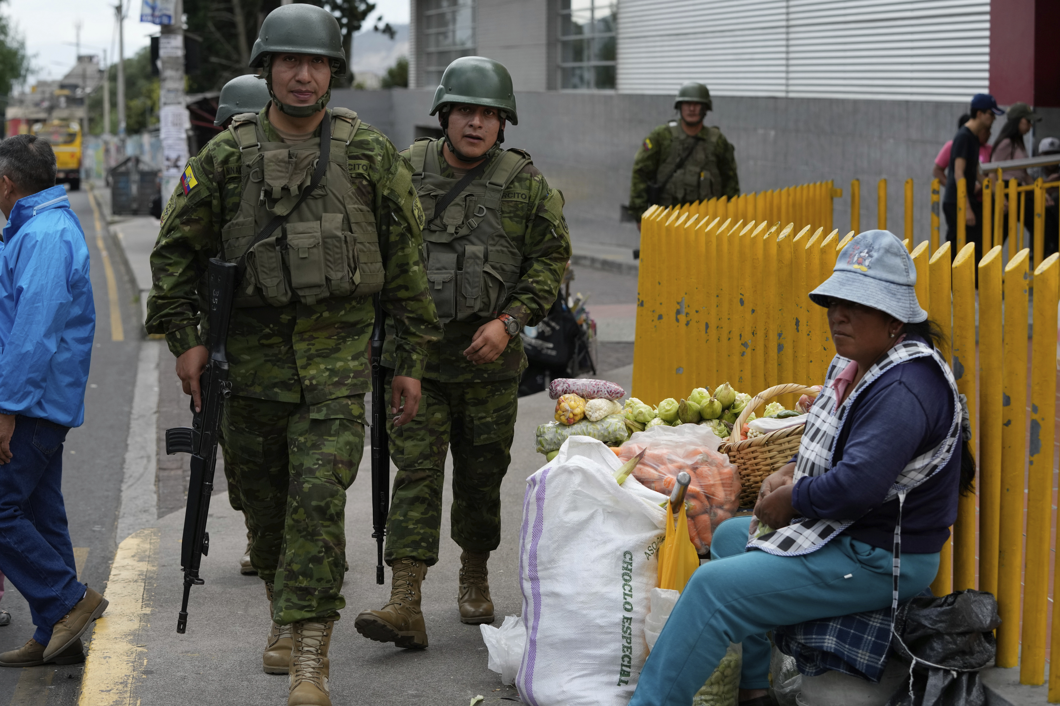 Military members walk past a street vendor.