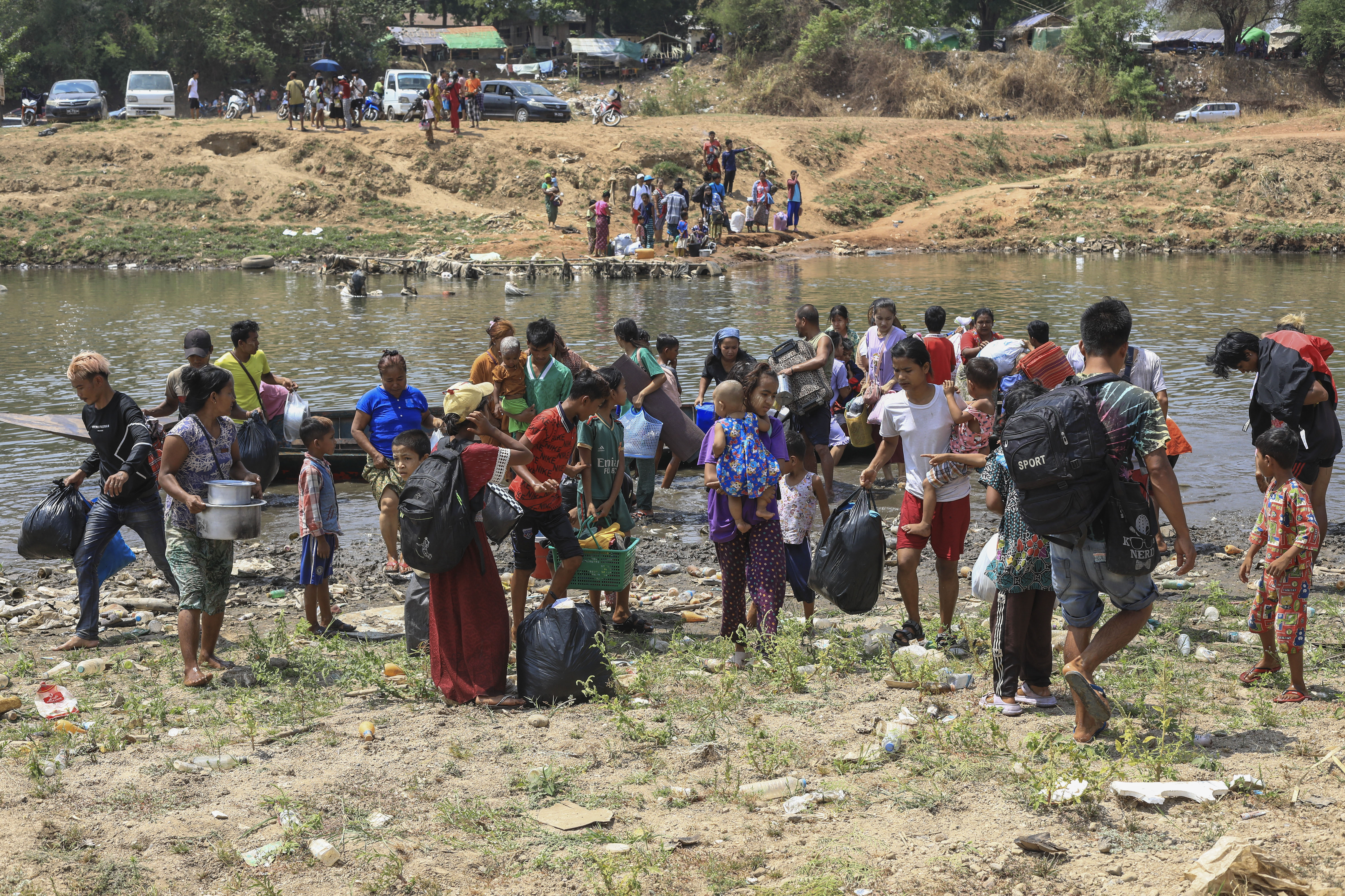 People cross the Moei river as they flee Myawaddy township